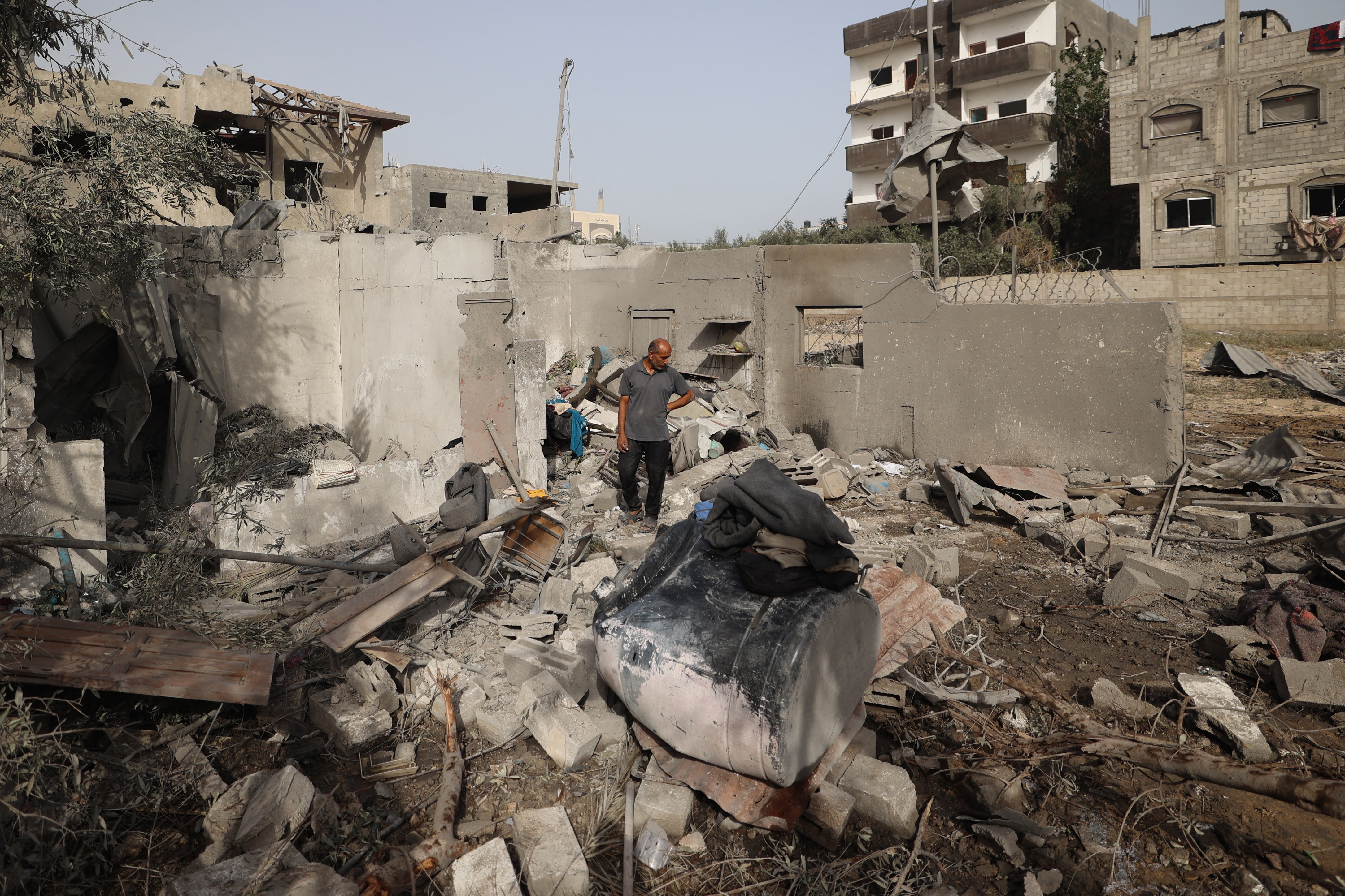 A Palestinian man inspects the rubble of a residential house.