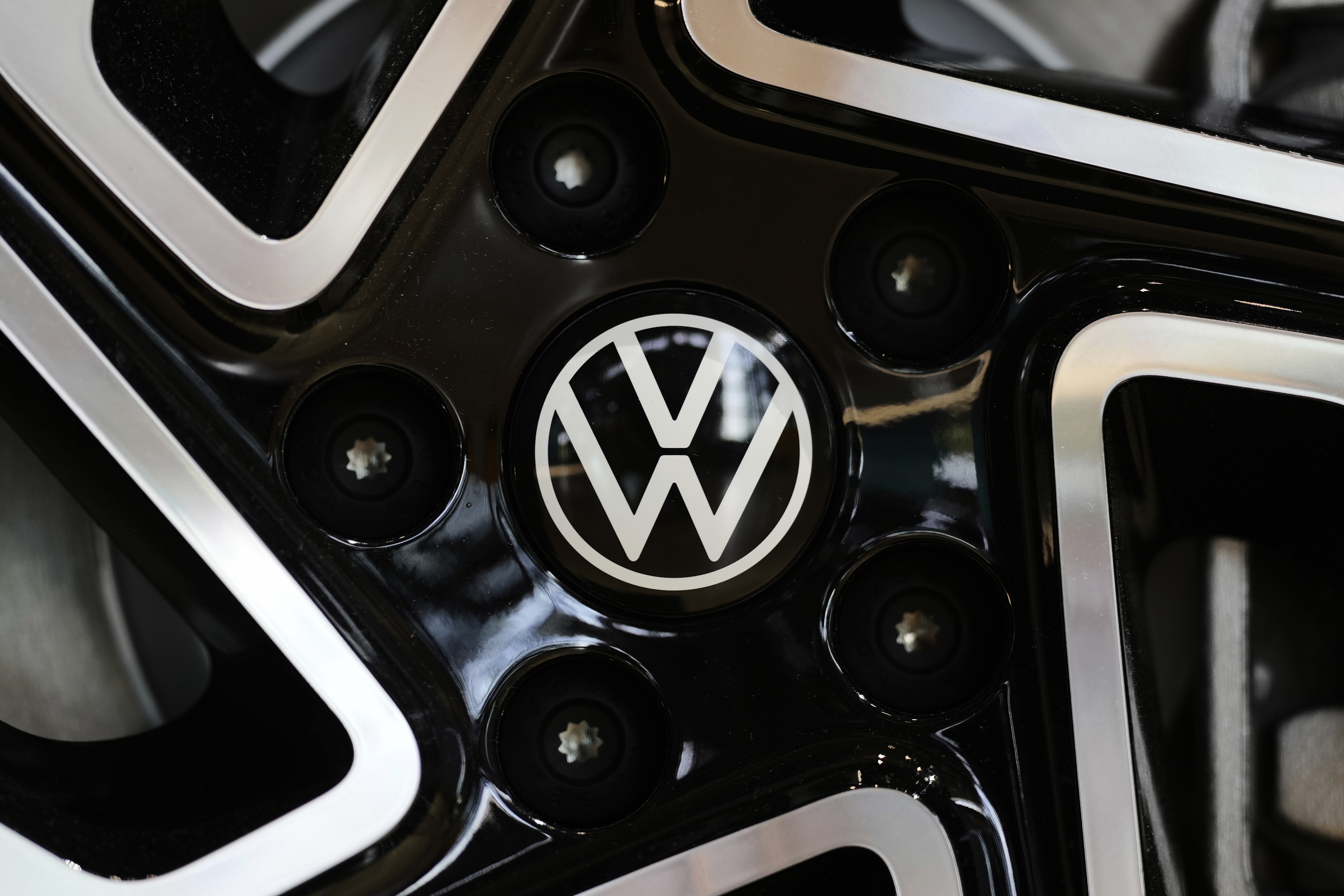 The logo of German car manufacturer Volkswagen is pictured at an ID.3 electric car at the transparent factory in Dresden, Germany, Wednesday, May 14, 2025. (AP Photo/Matthias Schrader)