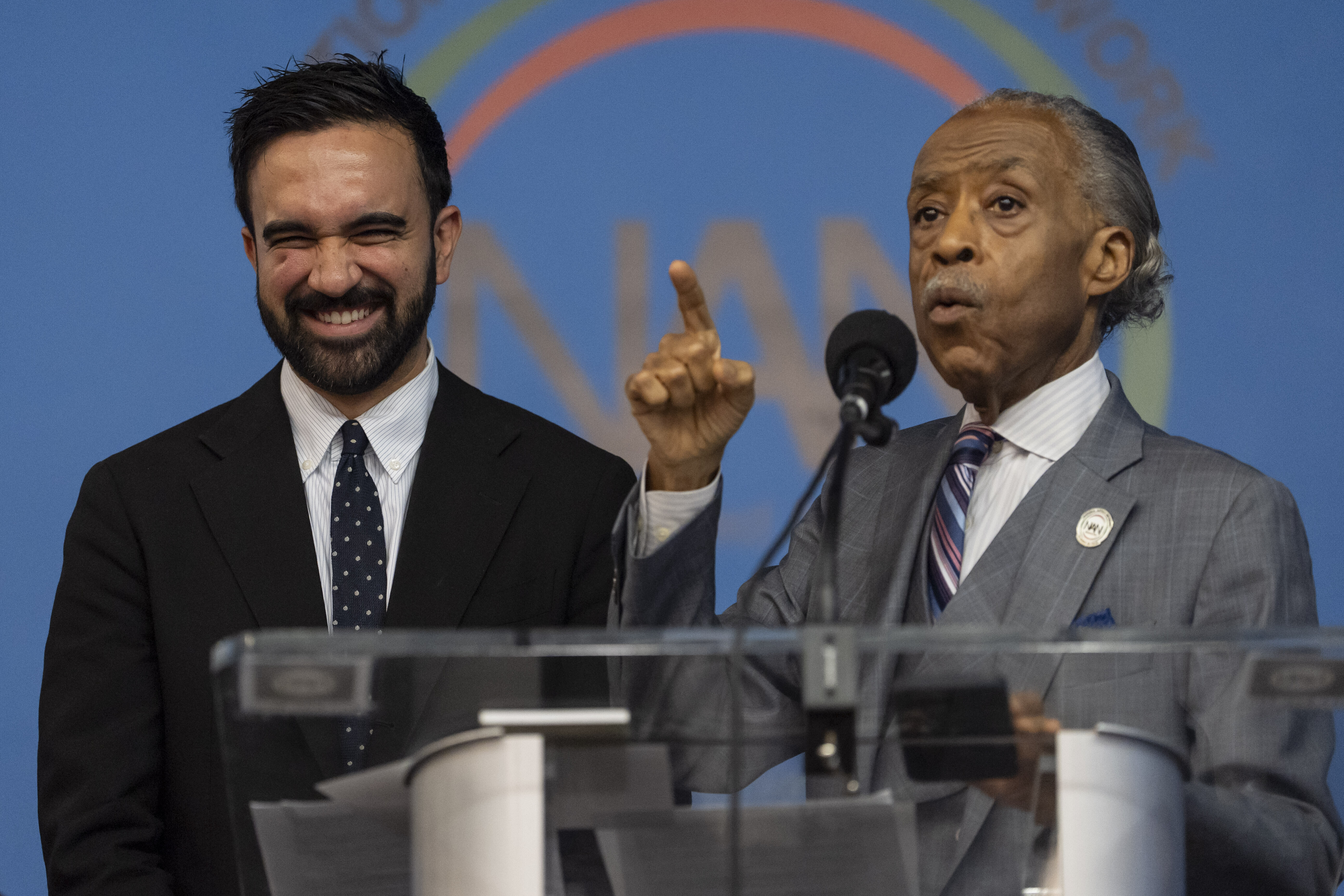 Zohran Mamdani and Al Sharpton stand behind a podium at a National Action Network meeting
