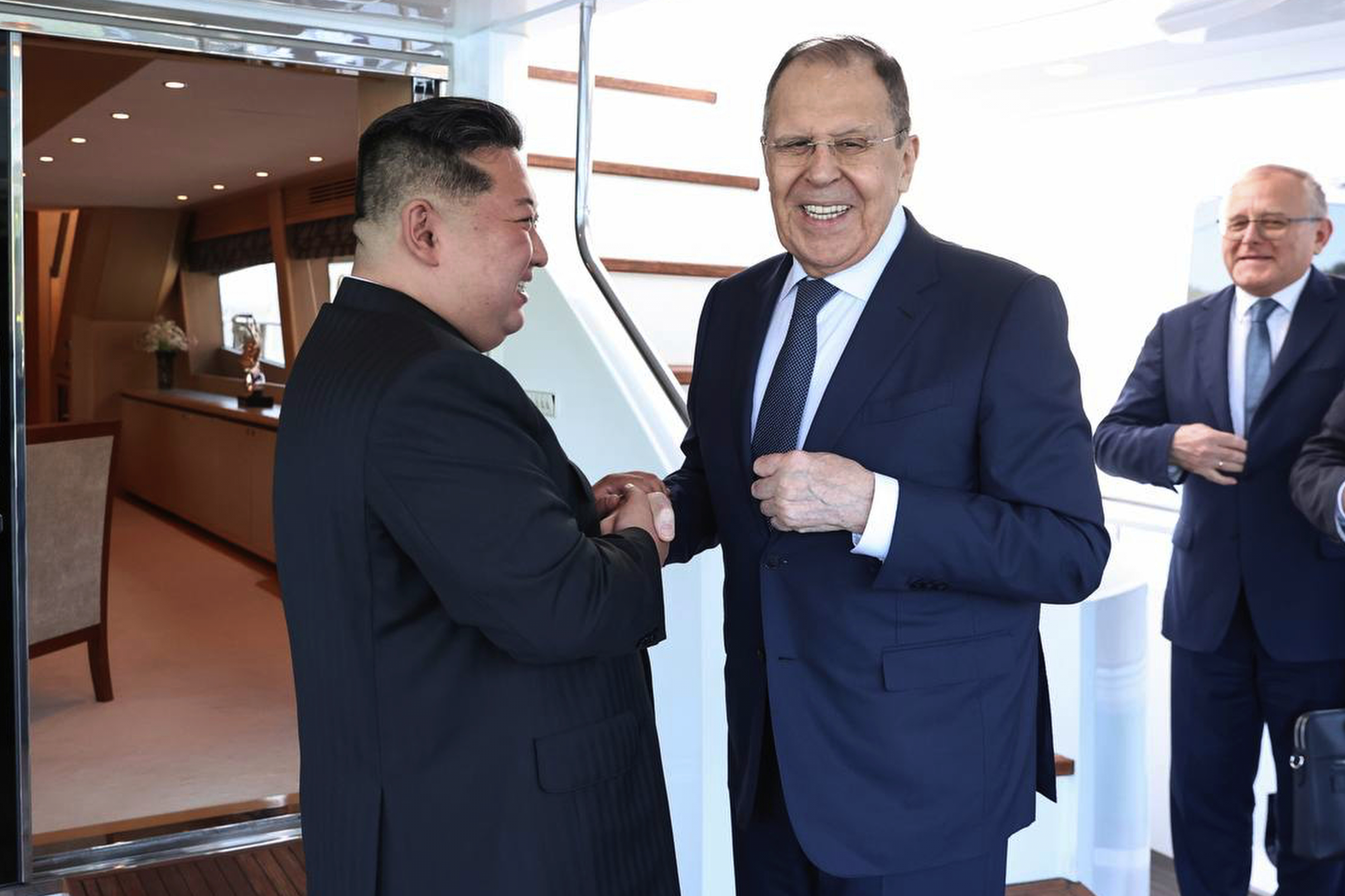 Russian Foreign Minister Sergey Lavrov, right, and North Korea's leader Kim Jong Un shake hands.