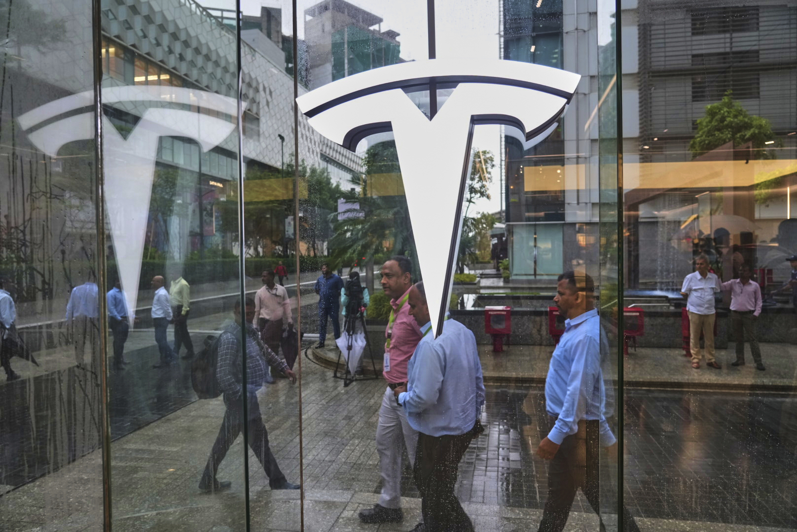 People walk past newly opened India's first Tesla showroom in Mumbai, India, Tuesday, July 15, 2025. (AP Photo/Rafiq Maqbool)
