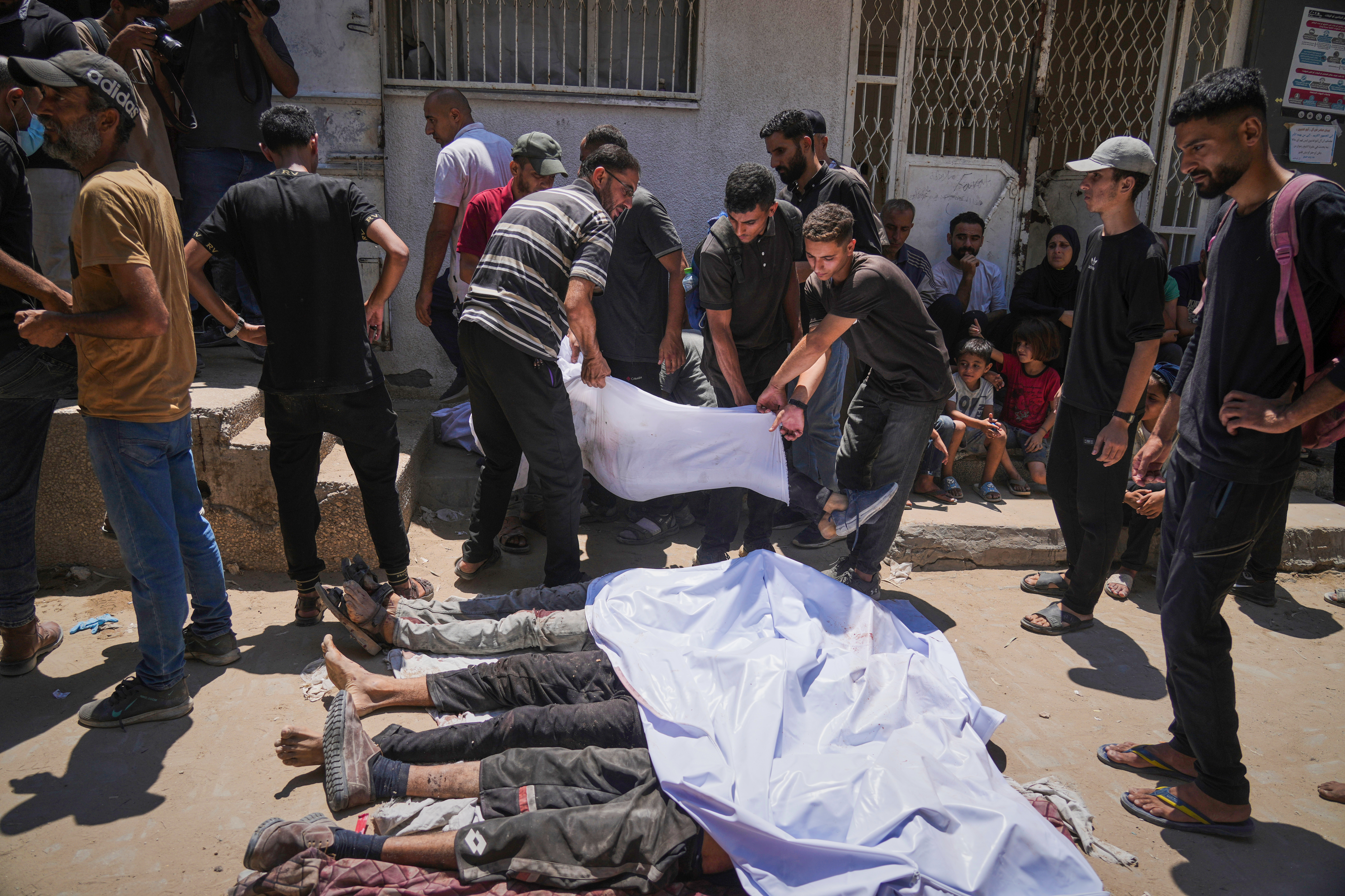 The bodies of Palestinians killed while trying to reach aid trucks entering northern Gaza through the Zikim crossing with Israel, are brought to Shifa Hospital in Gaza City on Sunday, July 20, 2025. (AP Photo/Jehad Alshrafi)