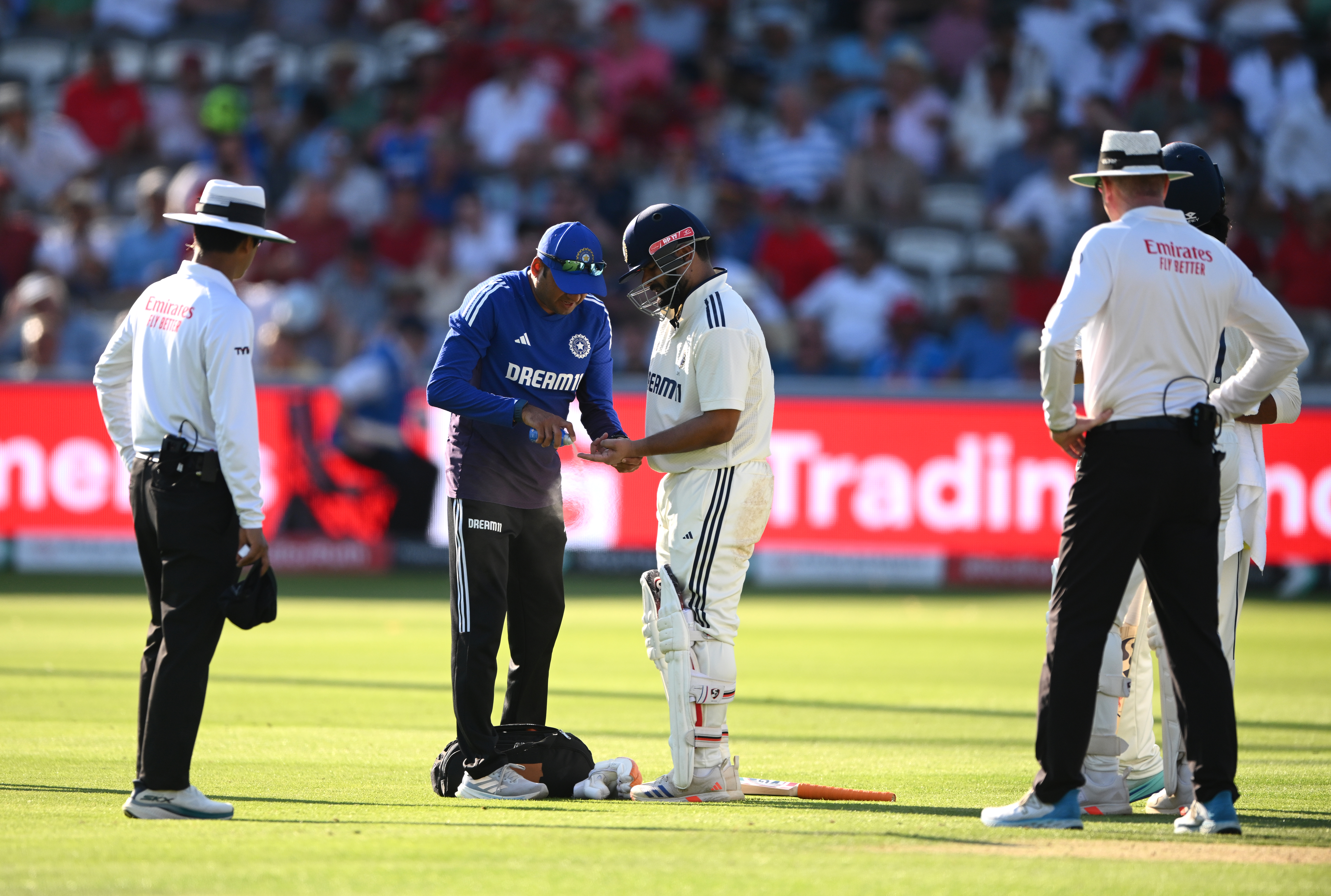 India batsman Rishabh Pant gets some medical attention to his injured finger as the umpires wait on during day two of the Third Test Match between England and India at Lord's