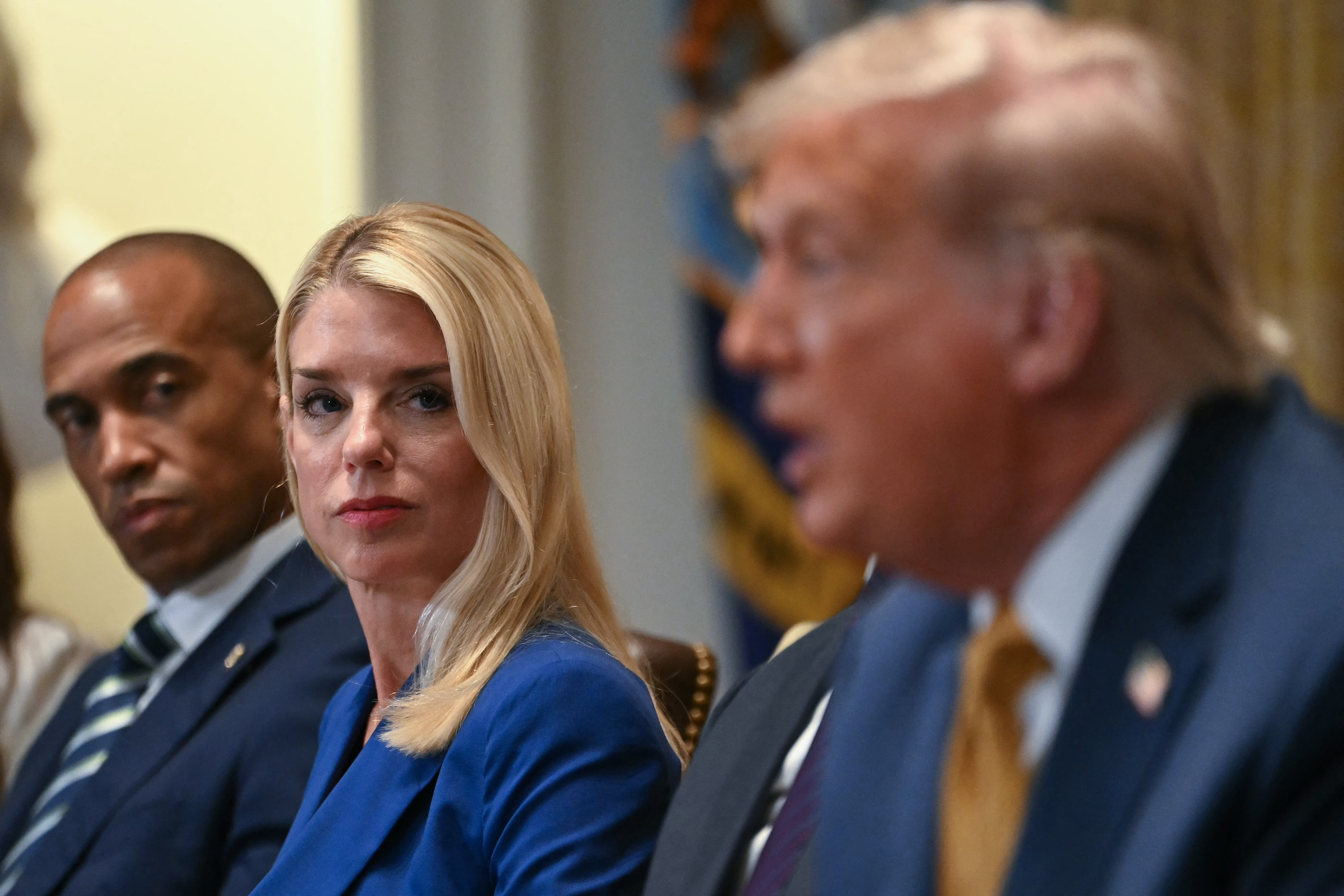 (L/R) US Secretary of Housing and Urban Development Scott Turner and Attorney General Pam Bondi look on as President Donald Trump speaks during a cabinet meeting in the Cabinet Room of the White House in Washington, DC, on July 8, 2025. (Photo by ANDREW CABALLERO-REYNOLDS / AFP)