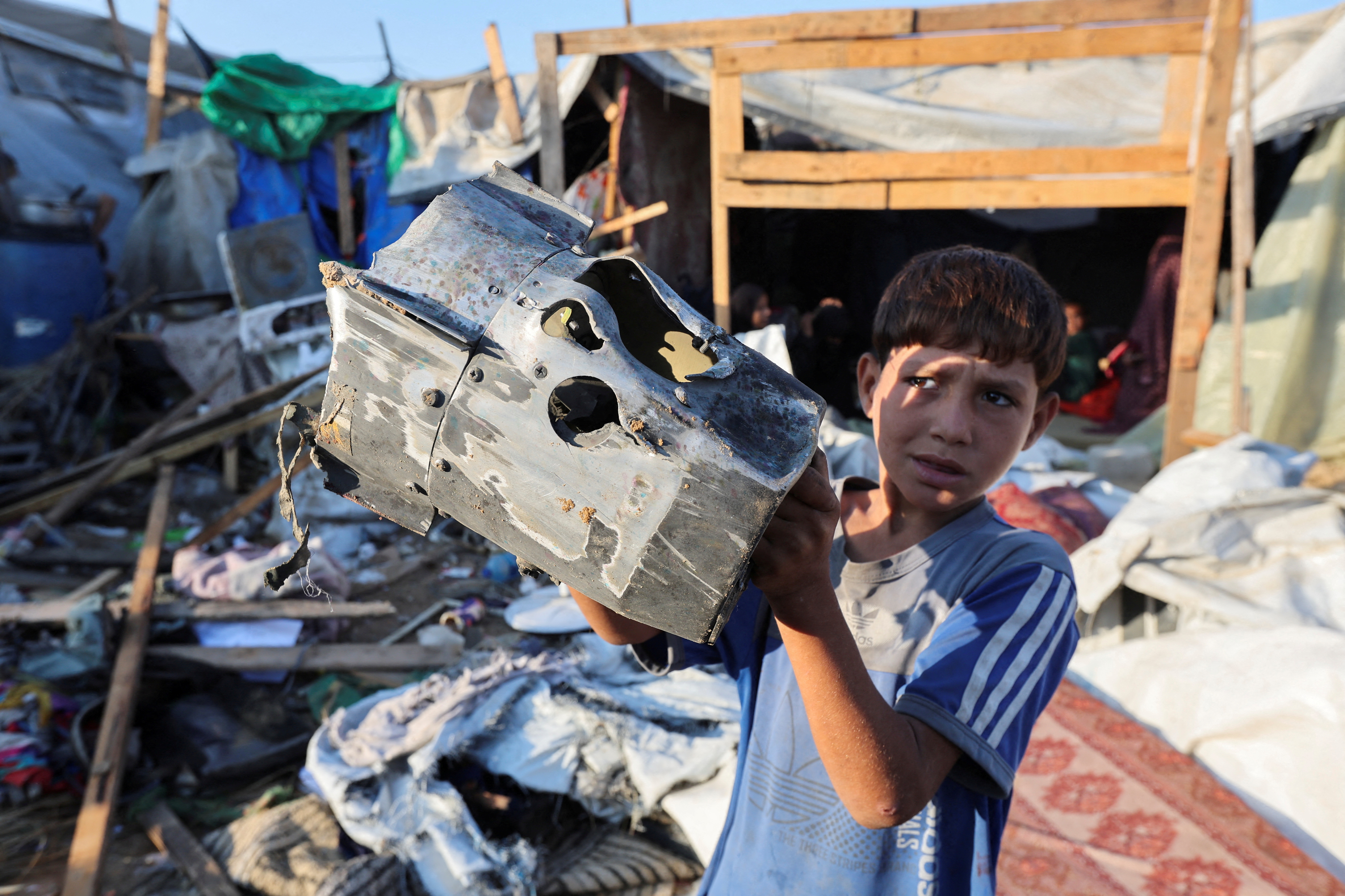 A Palestinian child holds the remains of a missile at the site of an Israeli strike on the courtyard of Al-Aqsa Martyrs hospital, where displaced people were taking shelter in tents, amid the Israel-Hamas conflict, in Deir Al-Balah in the central Gaza Strip, September 5, 2024. REUTERS/Ramadan Abed TPX IMAGES OF THE DAY
