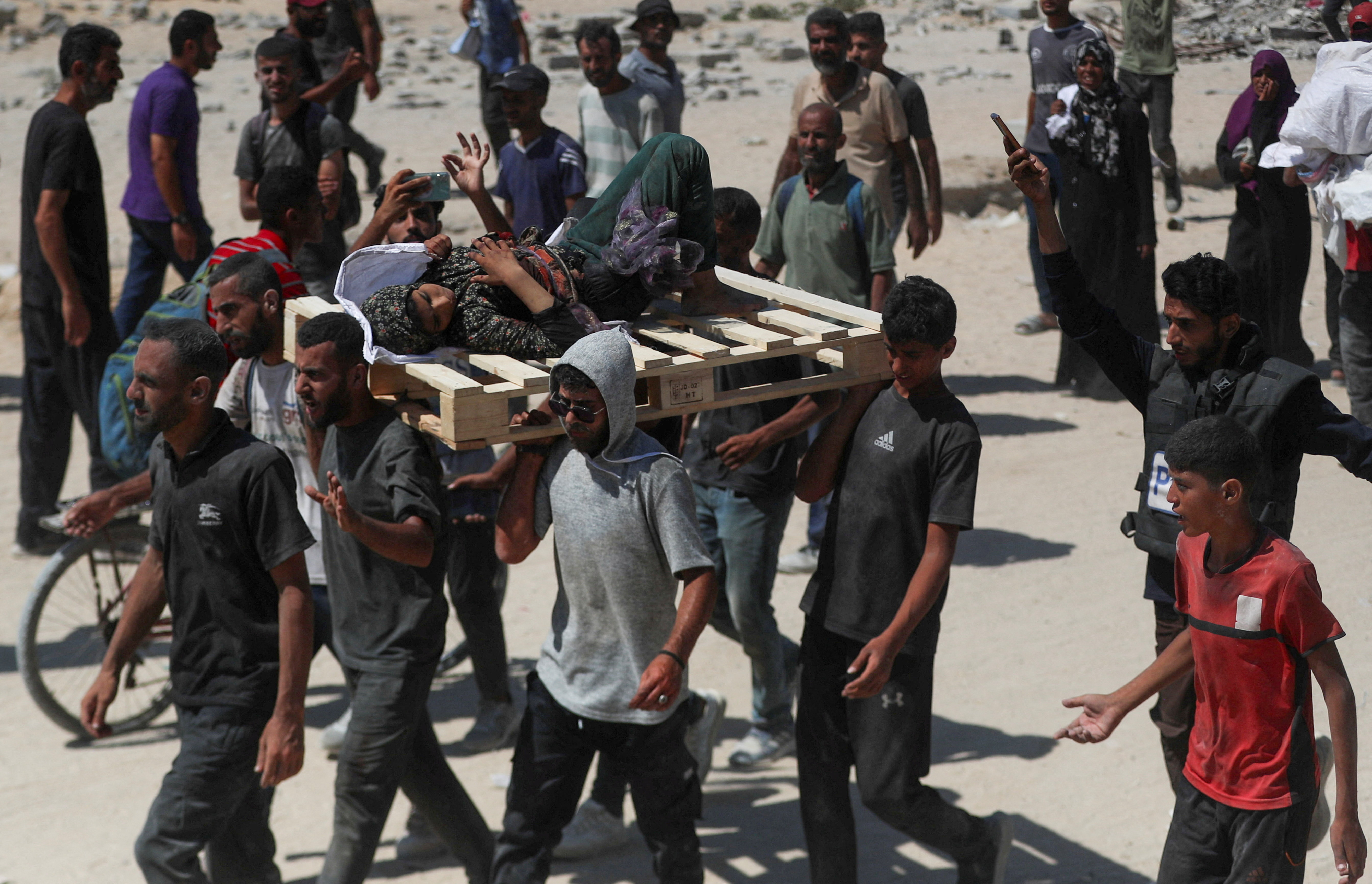 Palestinians carry a woman that was wounded by Israeli fire, as others seek aid supplies that entered Gaza through Israel, in Beit Lahia, northern Gaza Strip, August 1, 2025. [Mahmoud Issa/Reuters]
