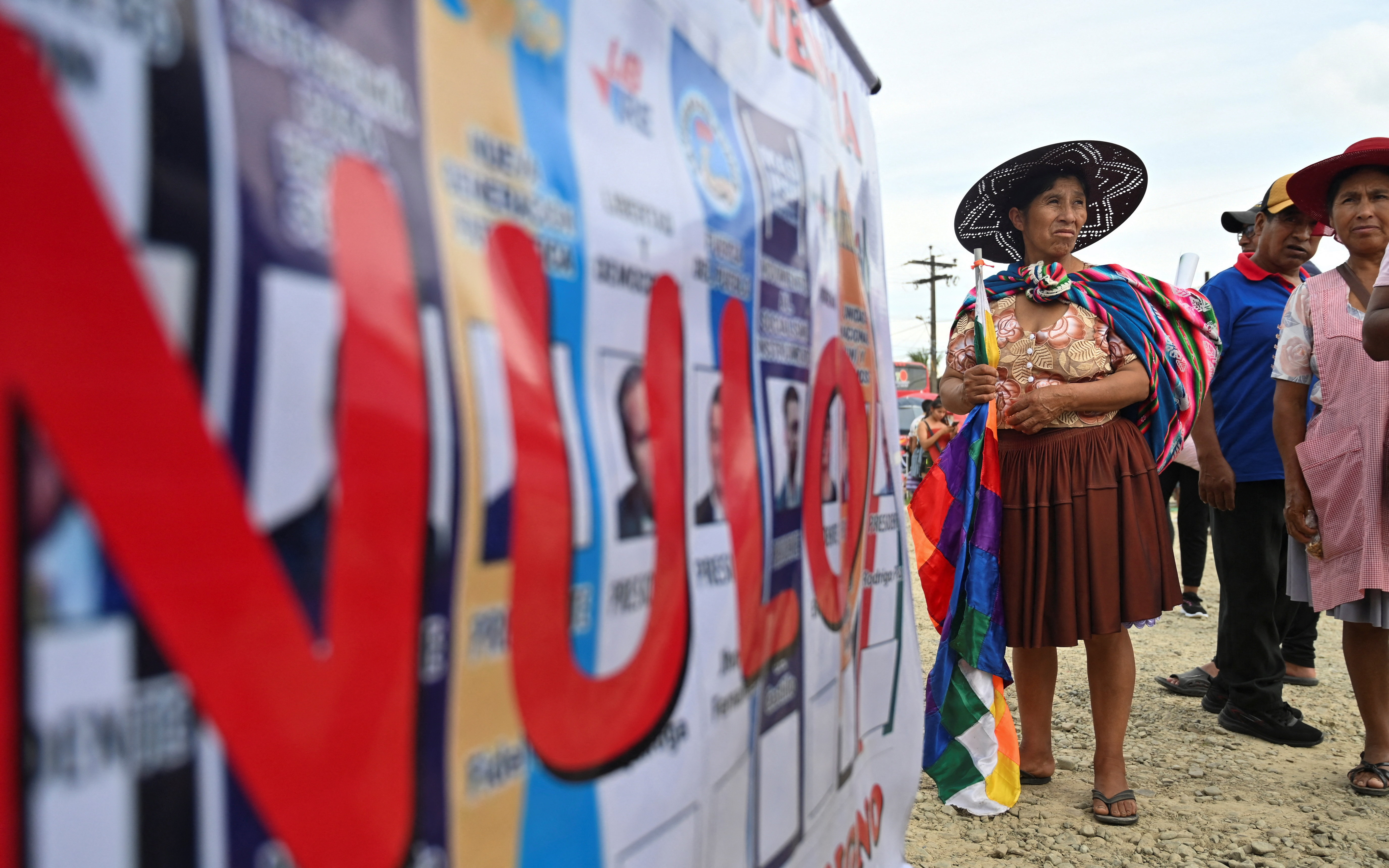 An Evo Morales supporter walks past a wall of mock ballots spray-painted with the word "Nulo"