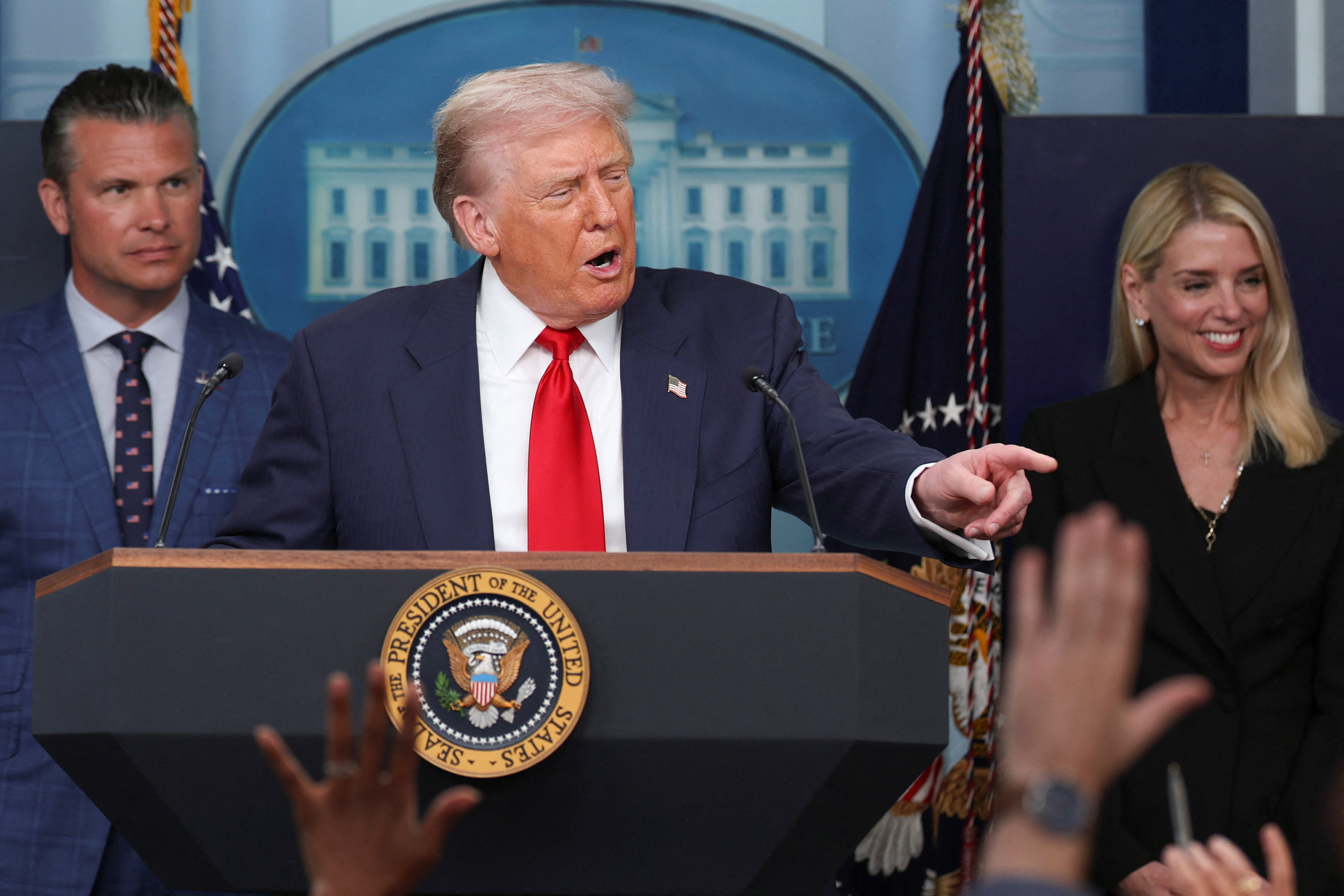 U.S. President Donald Trump speaks next to U.S. Defense Secretary Pete Hegseth and U.S. Attorney General Pam Bondi