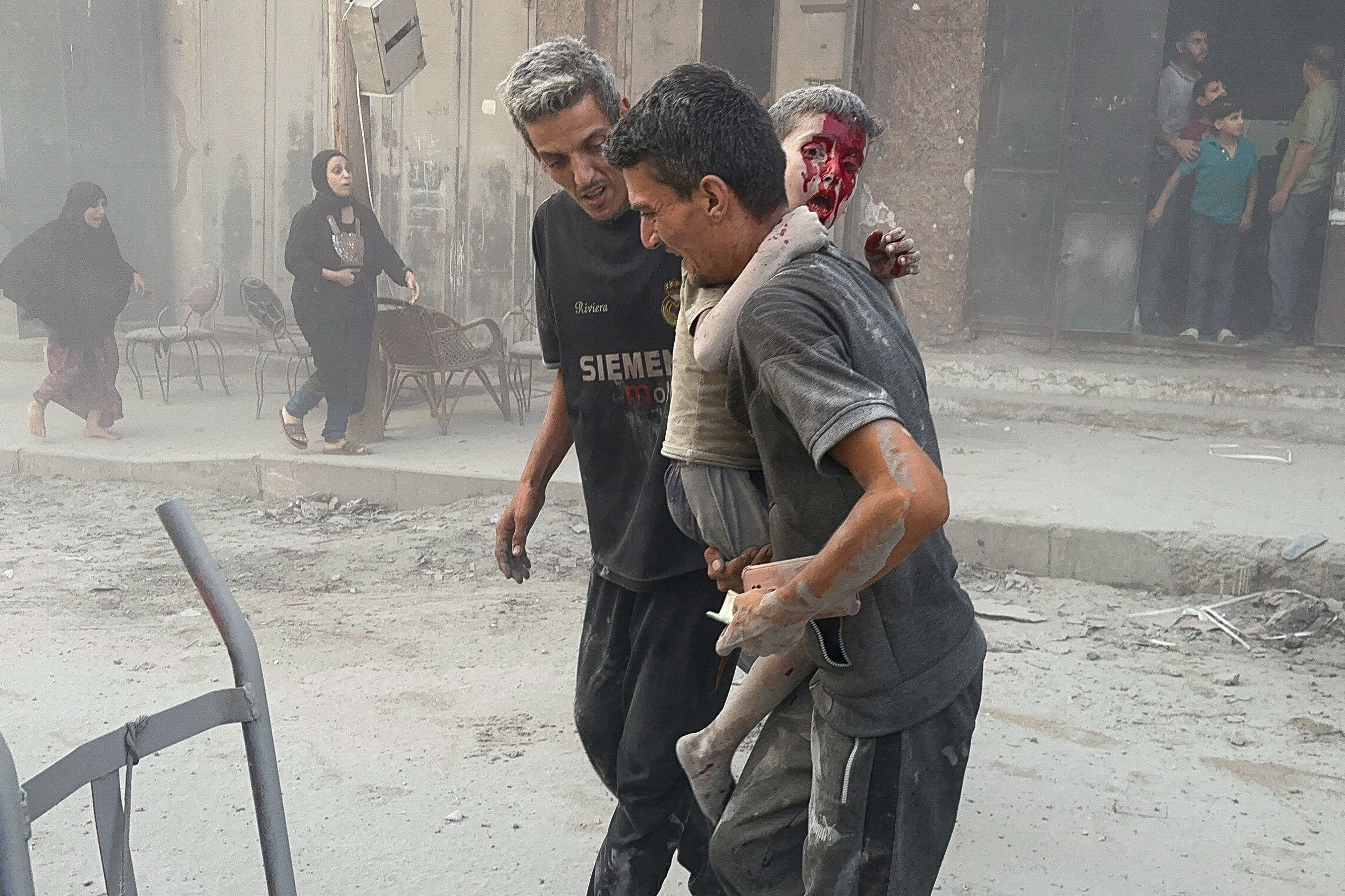 Palestinian man carries a wounded boy at the site of an Israeli strike on a residential building, in Gaza City August 30, 2025. [Reuters]
