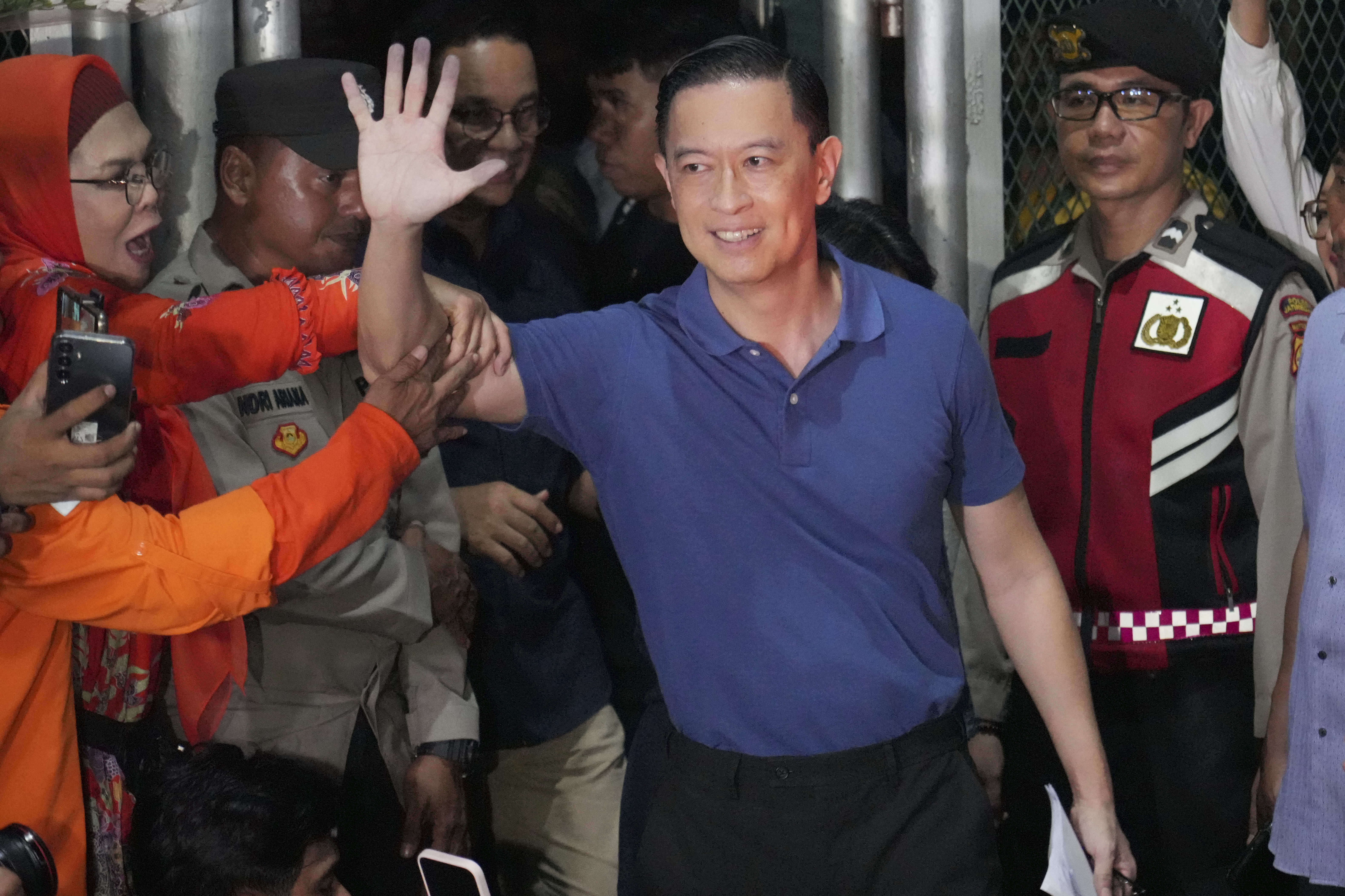 Indonesia's former Trade Minister Tom Lembong, center, who was sentenced to more than four years, waves to the media as he leaves Cipinang prison in Jakarta, Indonesia, Friday, Aug. 1, 2025. (AP Photo/Achmad Ibrahim)