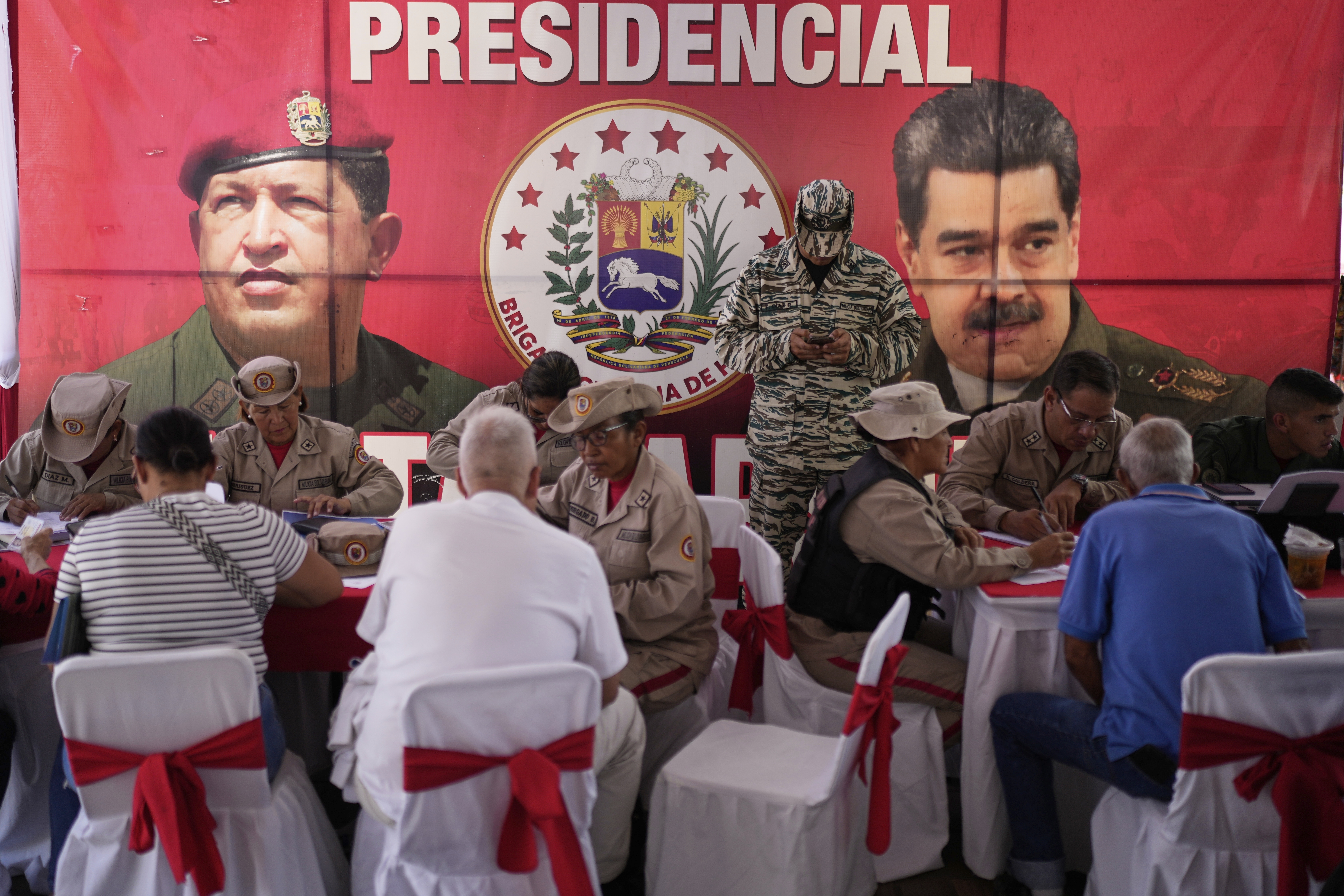 People sign up during a national enlistment drive to join the civil militias, called by the government of President Nicolas Maduro, at a square in Caracas, Venezuela, Saturday, Aug. 23, 2025. (AP Photo/Ariana Cubillos)