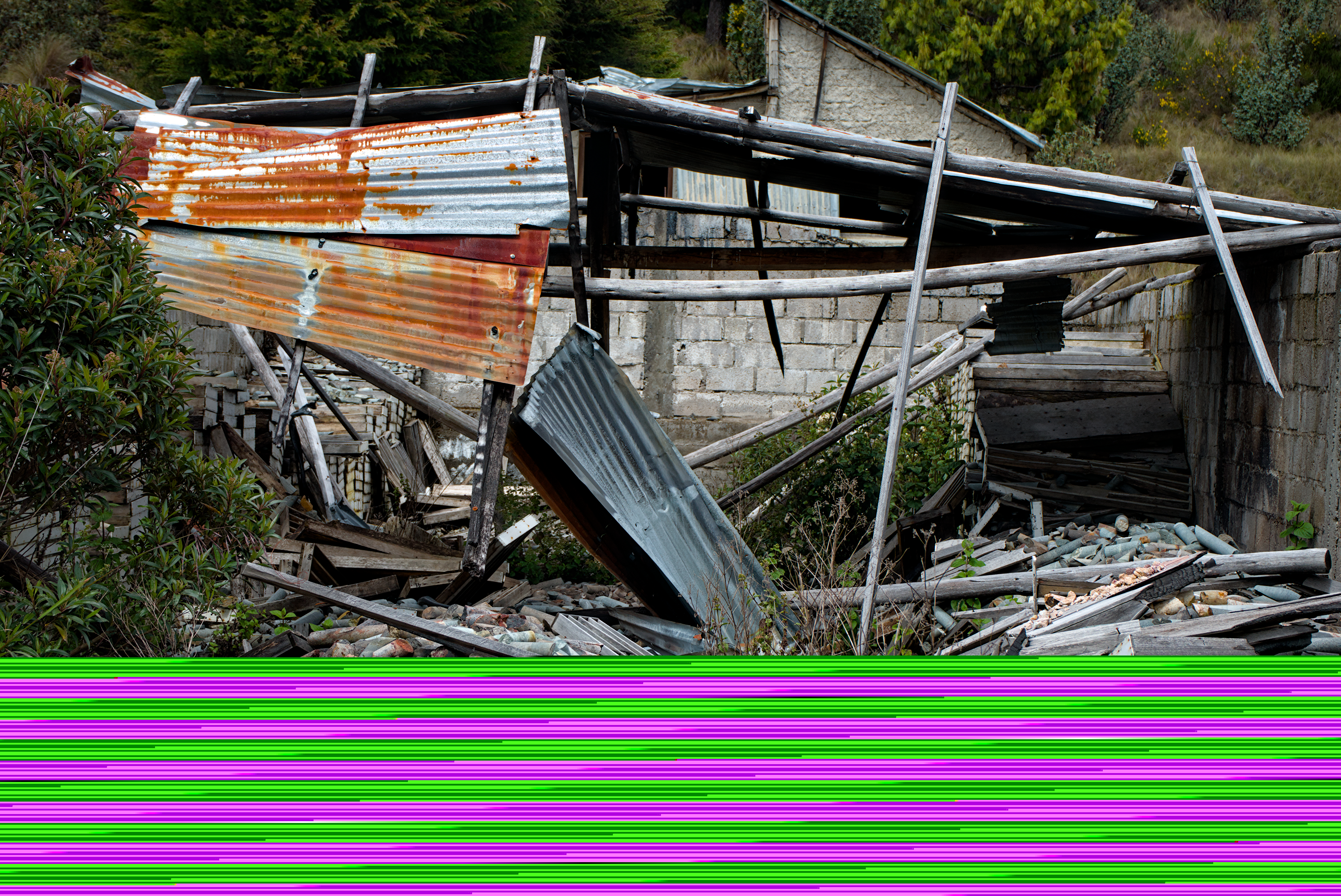 A rusted corrugated metal roof tumbles onto extracted mineral cores