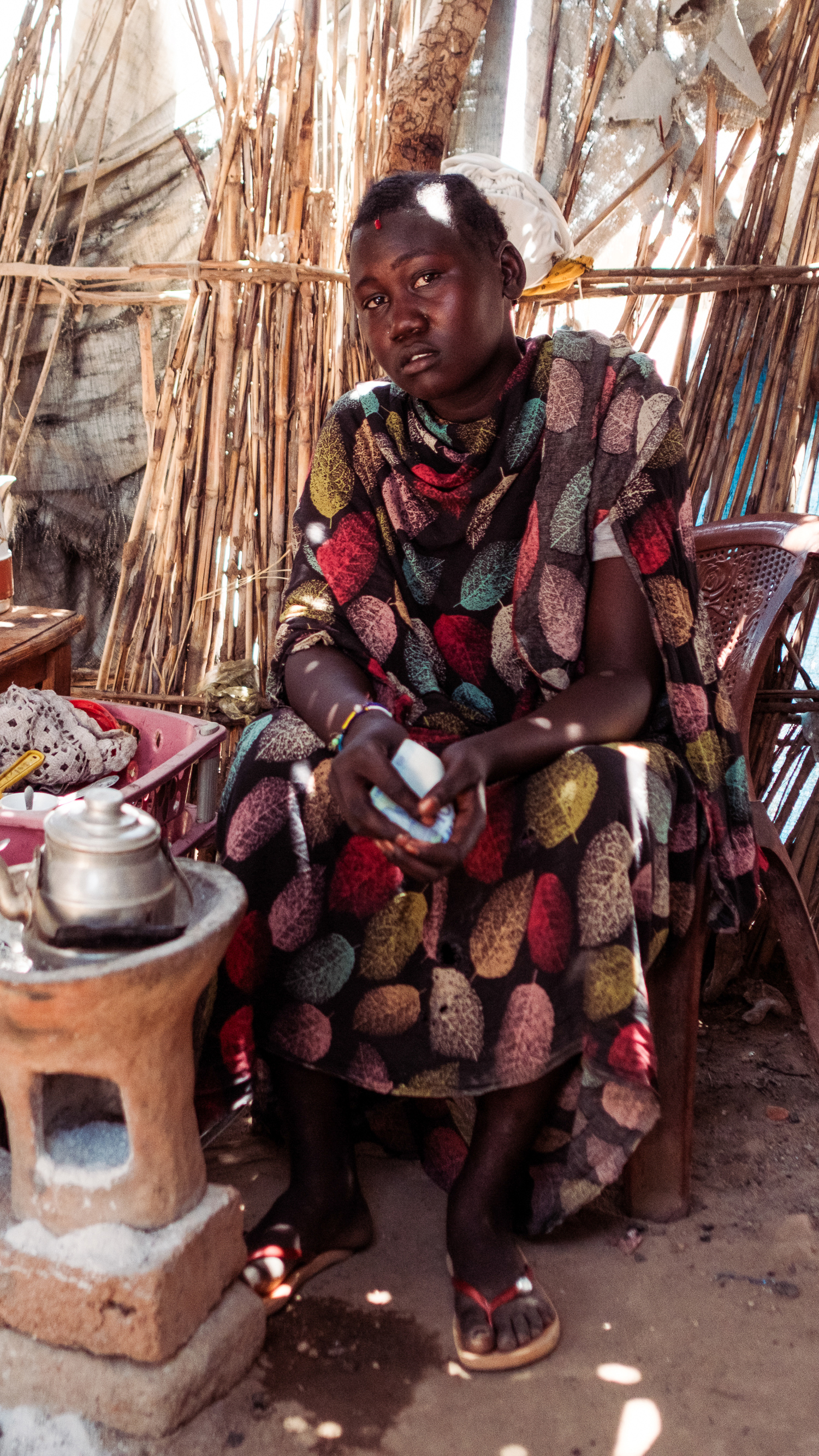 Ibtisam Hilmi, 14, displaced by fighting between the RSF and the SAF sits serving tea and coffee for the many RSF fighters In Tongoli on April 22, 2025 [Guy Peterson/Al Jazeera]
