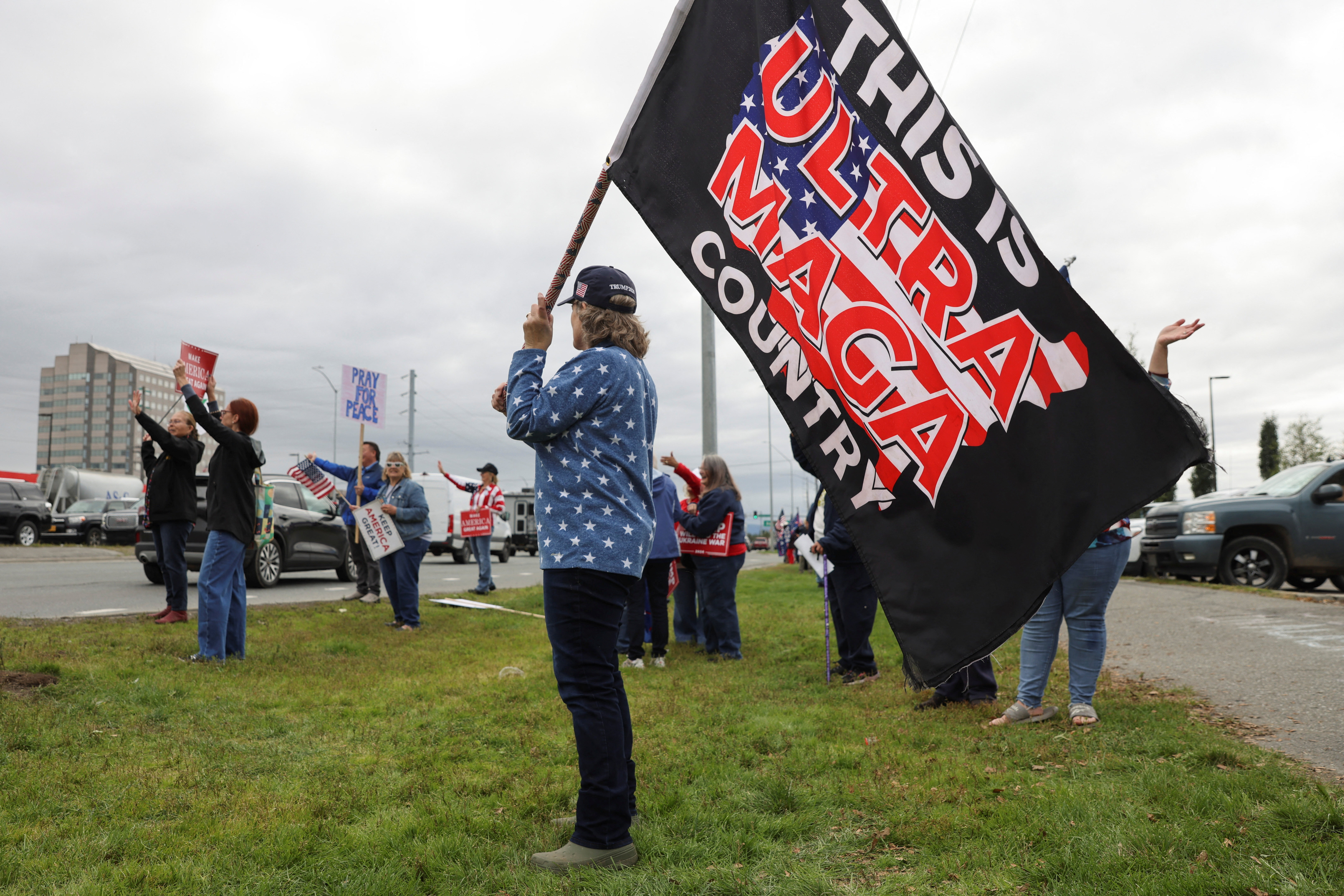 A demonstrator holds a flag that reads "this is ultra MAGA country", during a rally in support of U.S. President Donald Trump, on the day Trump meets with Russia's President Vladimir Putin to negotiate an end to the war in Ukraine, in Midtown Anchorage, Alaska, U.S., August 15, 2025. REUTERS/Nathaniel Wilder