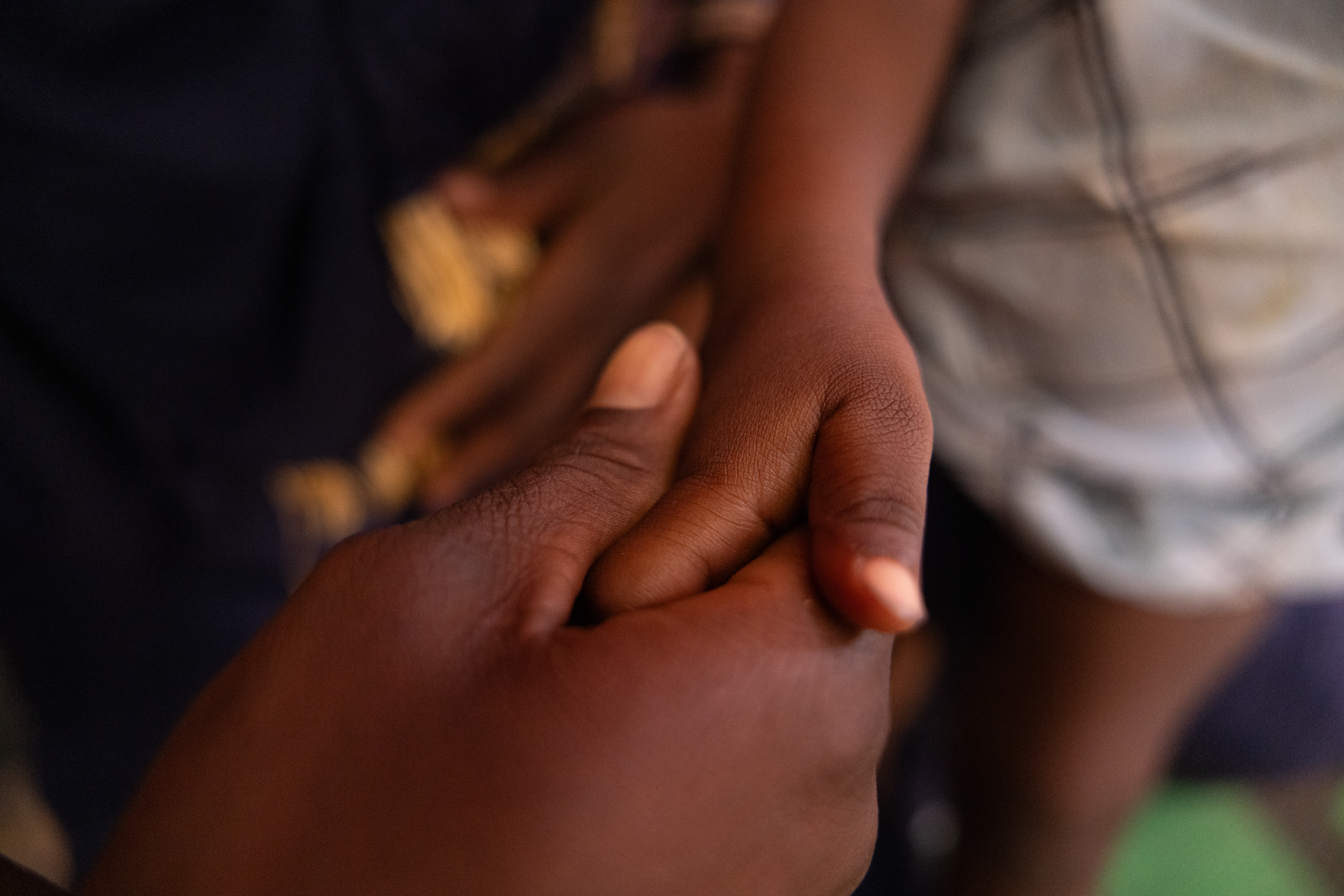 Lacham holds 3 year old Halwa - who was raped by their neighbour in the Adre transit camp. Caitlin Kelly