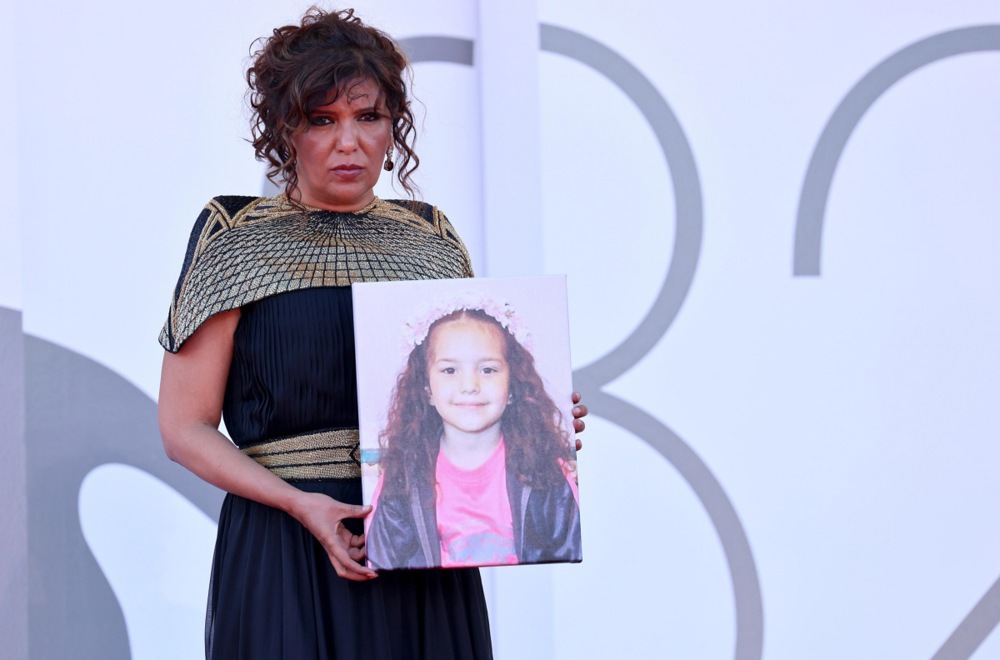 epa12349131 Tunisian director Kaouther Ben Hania displays a picture of Hind Rajab as she arrives for the premiere of 'The Voice of Hind Rajab' at the 82nd Venice Film Festival in Venice, Italy, 03 September 2025. The 82nd Venice Film Festival runs from 28 August to 06 September 2025. EPA/ETTORE FERRARI