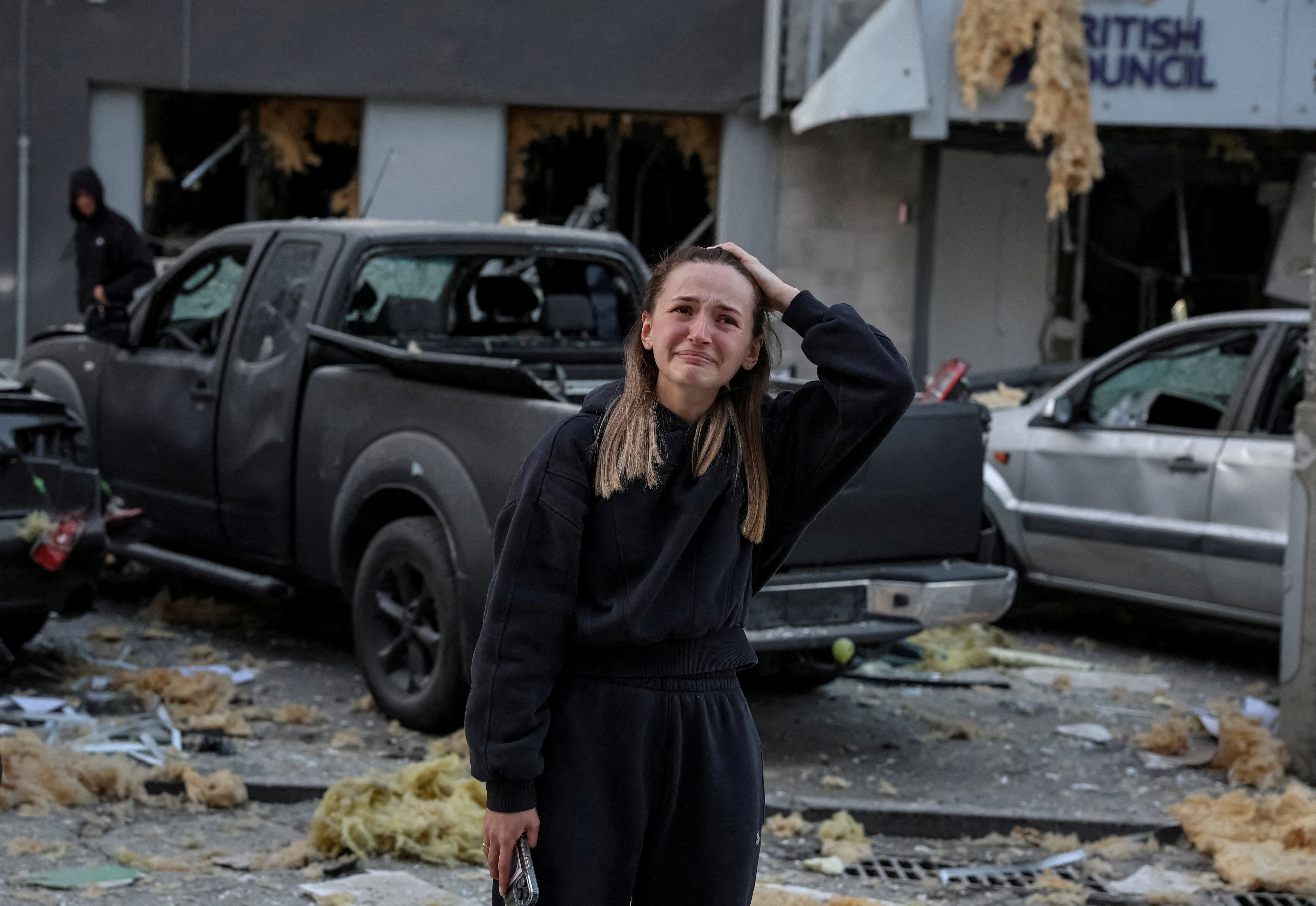 A woman reacts near a building housing the local branch of the British Council, as she stands at the site of an apartment building hit during Russian drone and missile strikes, amid Russia's attack on Ukraine, in Kyiv, Ukraine August 28, 2025. REUTERS/Stringer TPX IMAGES OF THE DAY