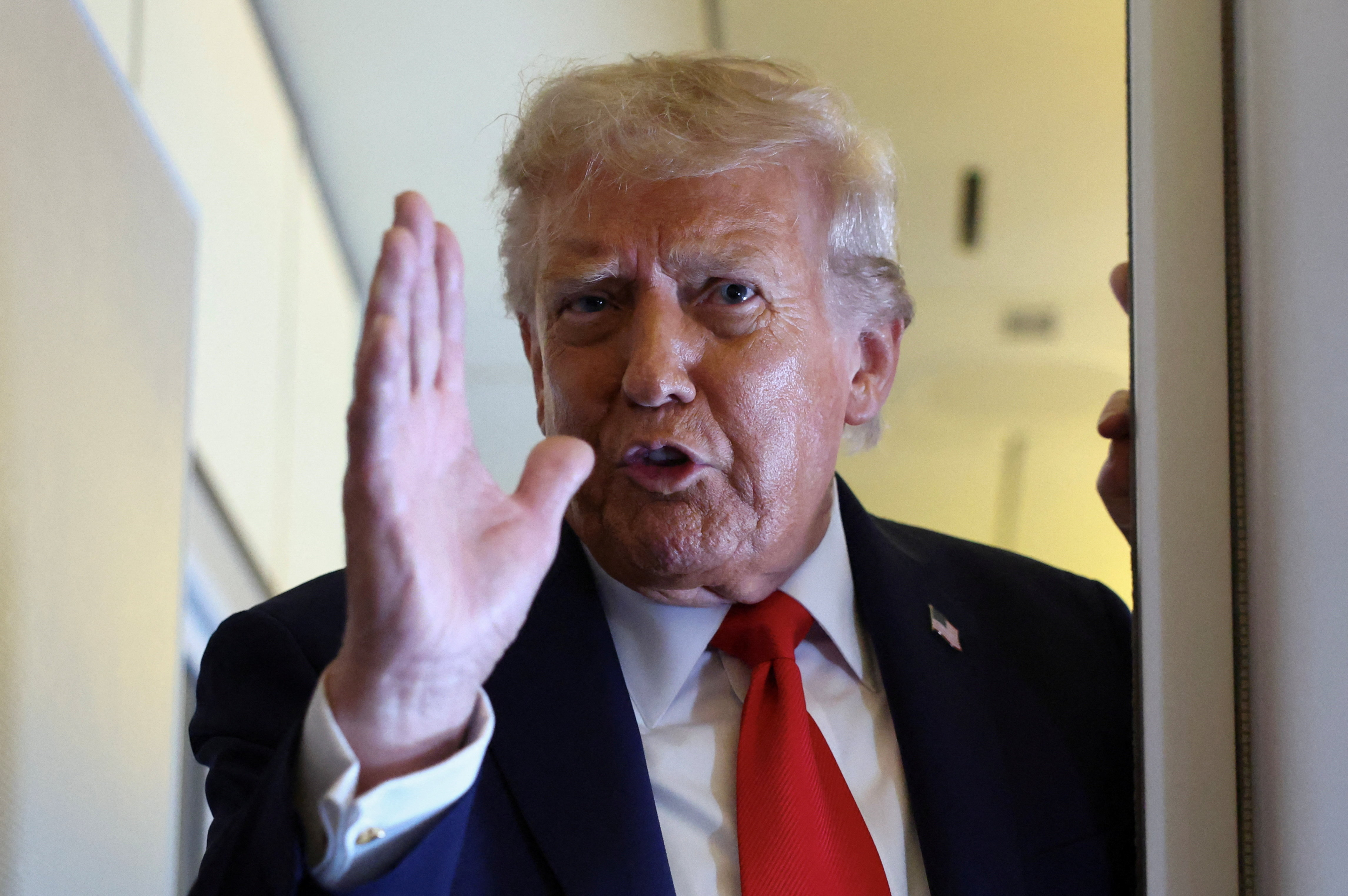Trump speaks aboard Air Force One on his return from a state visit in Britain