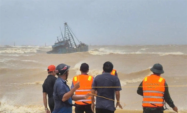 Rescue forces assist a fishing boat stranded at the breakwater of Cửa Việt channel