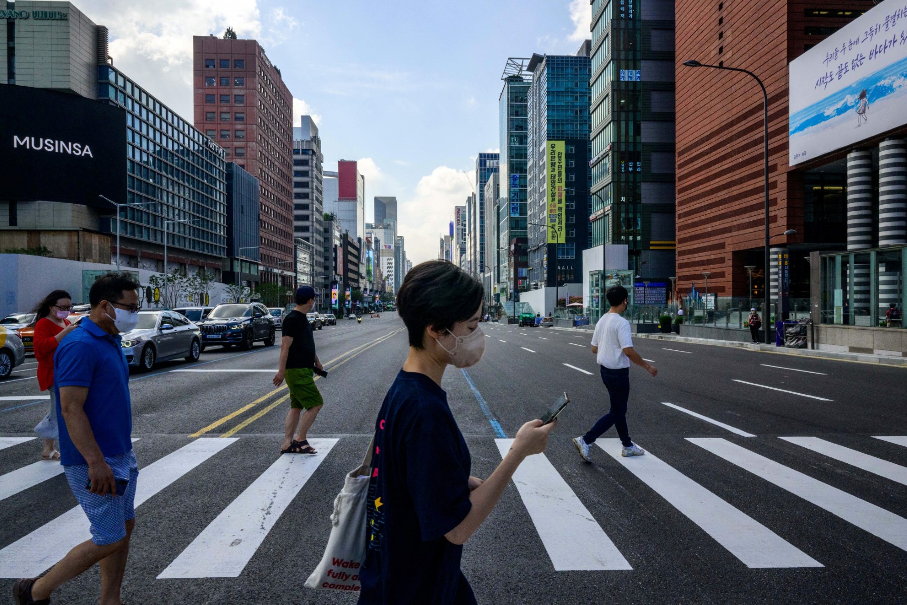 Pedestrians walk across a road in the Gangnam district of Seoul.