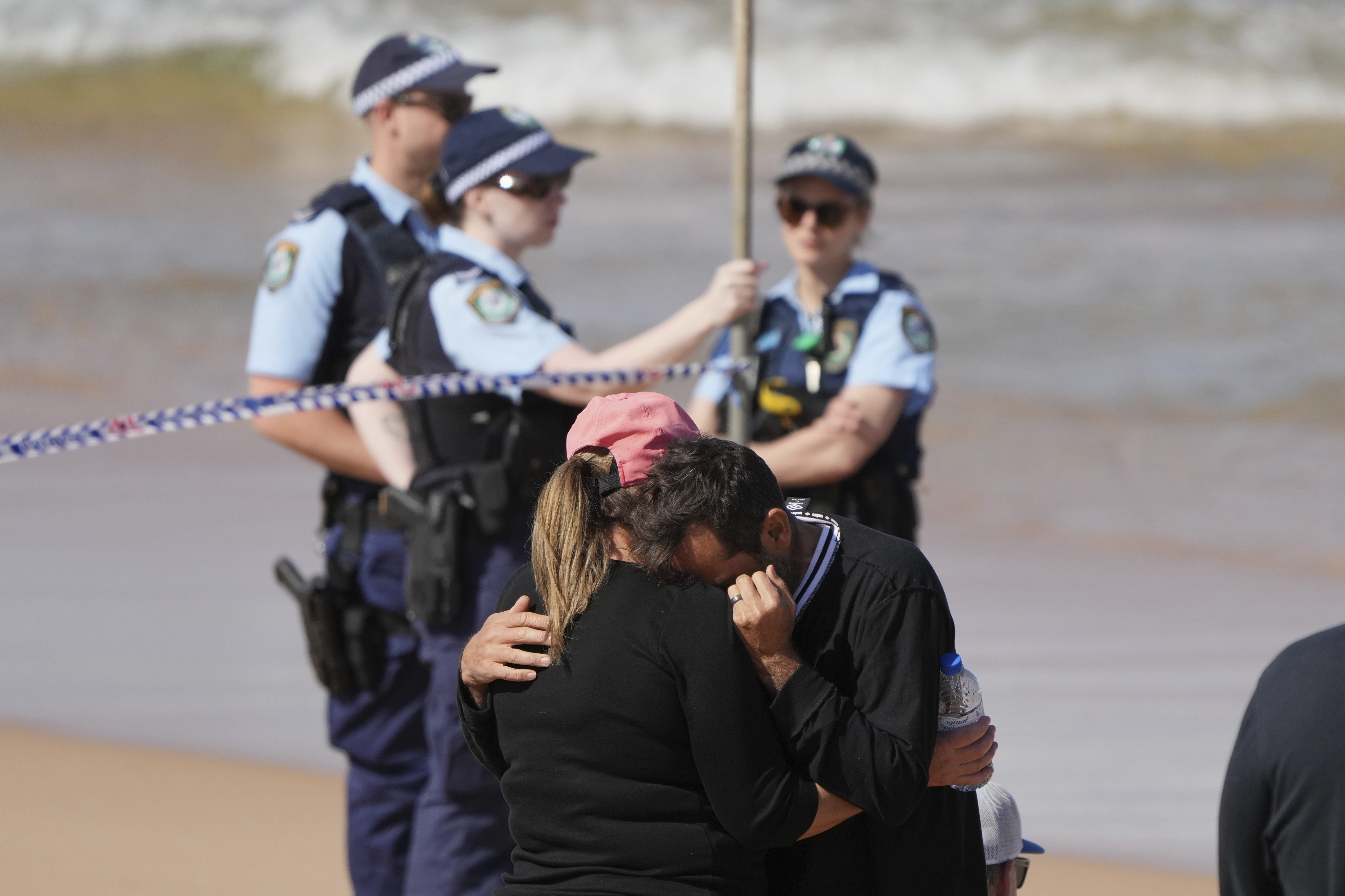 A man is consoled at the site of a fatal shark attack at Dee Why Beach in Sydney, Australia, Saturday, Sept. 6, 2025. (AP Photo/Mark Baker)