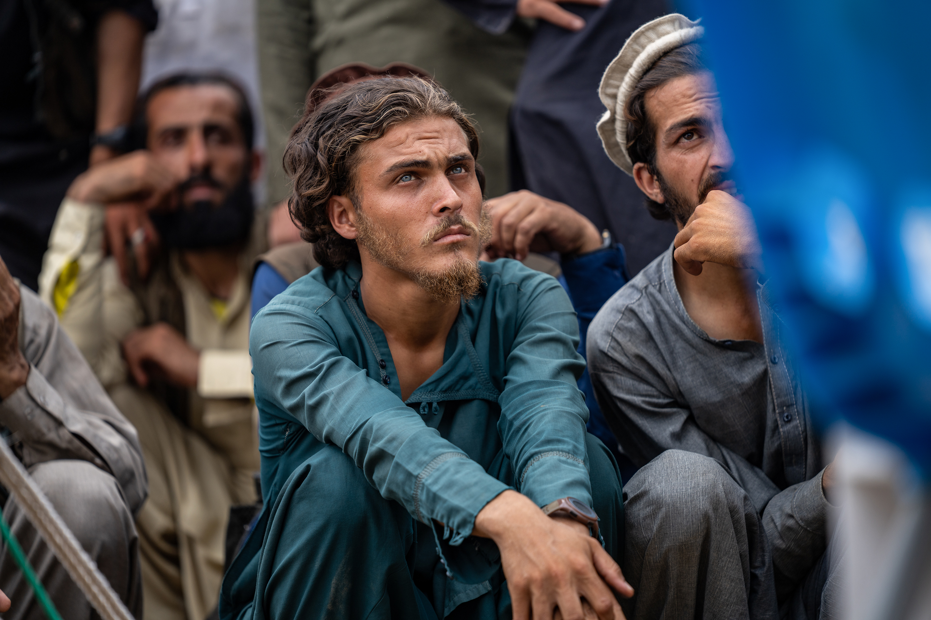 People wait for aid distributed by local businessmen in a displacement camp near Andarlachak village.