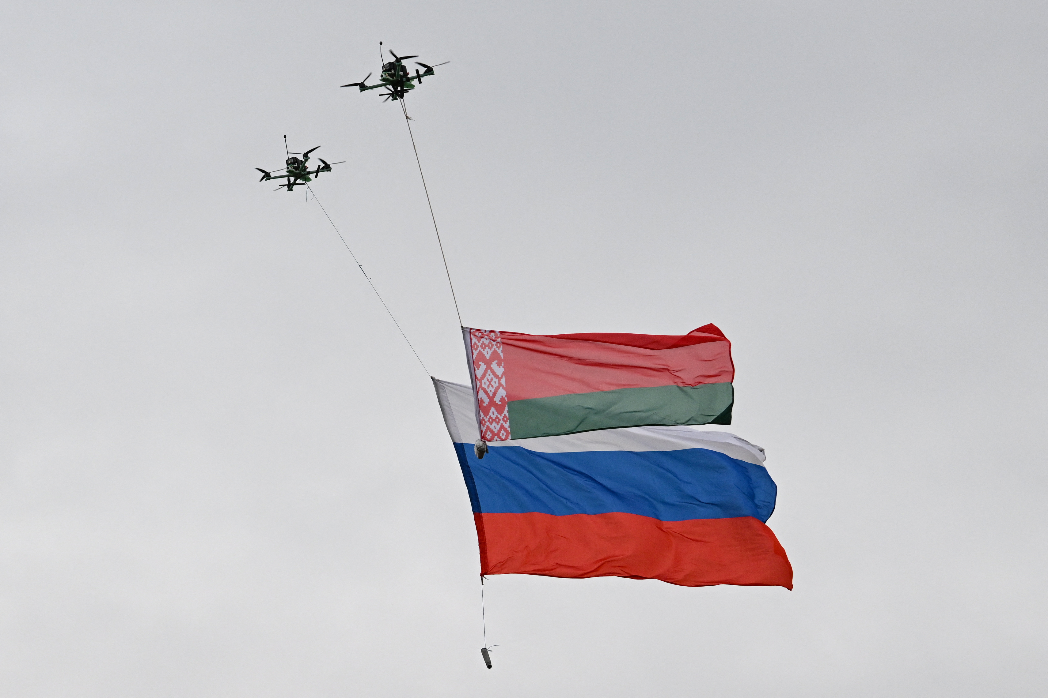Drones fly with flags of Russia and Belarus during the "Zapad-2025" (West-2025) joint Russian-Belarusian military drills at a training ground near the town of Borisov, east of the capital Minsk, on September 15, 2025. (Photo by Olesya KURPYAYEVA / AFP)