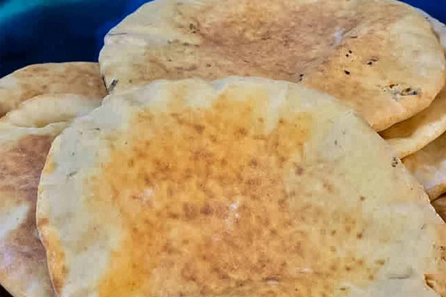 Close-up of loaves of Palestinian bread made with lentils, bearing soot marks from the rudimentary oven it was made in