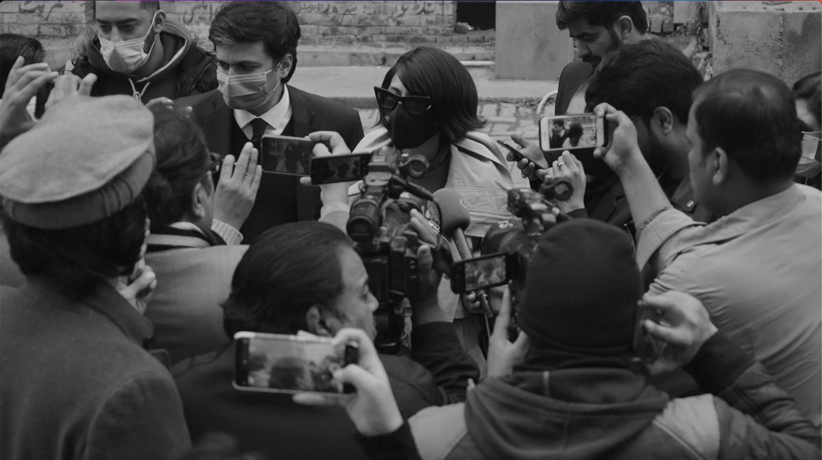 A still from the video for the song Azaab (Torment) showing Meesha Shafi speaking with journalists outside a court in Lahore.