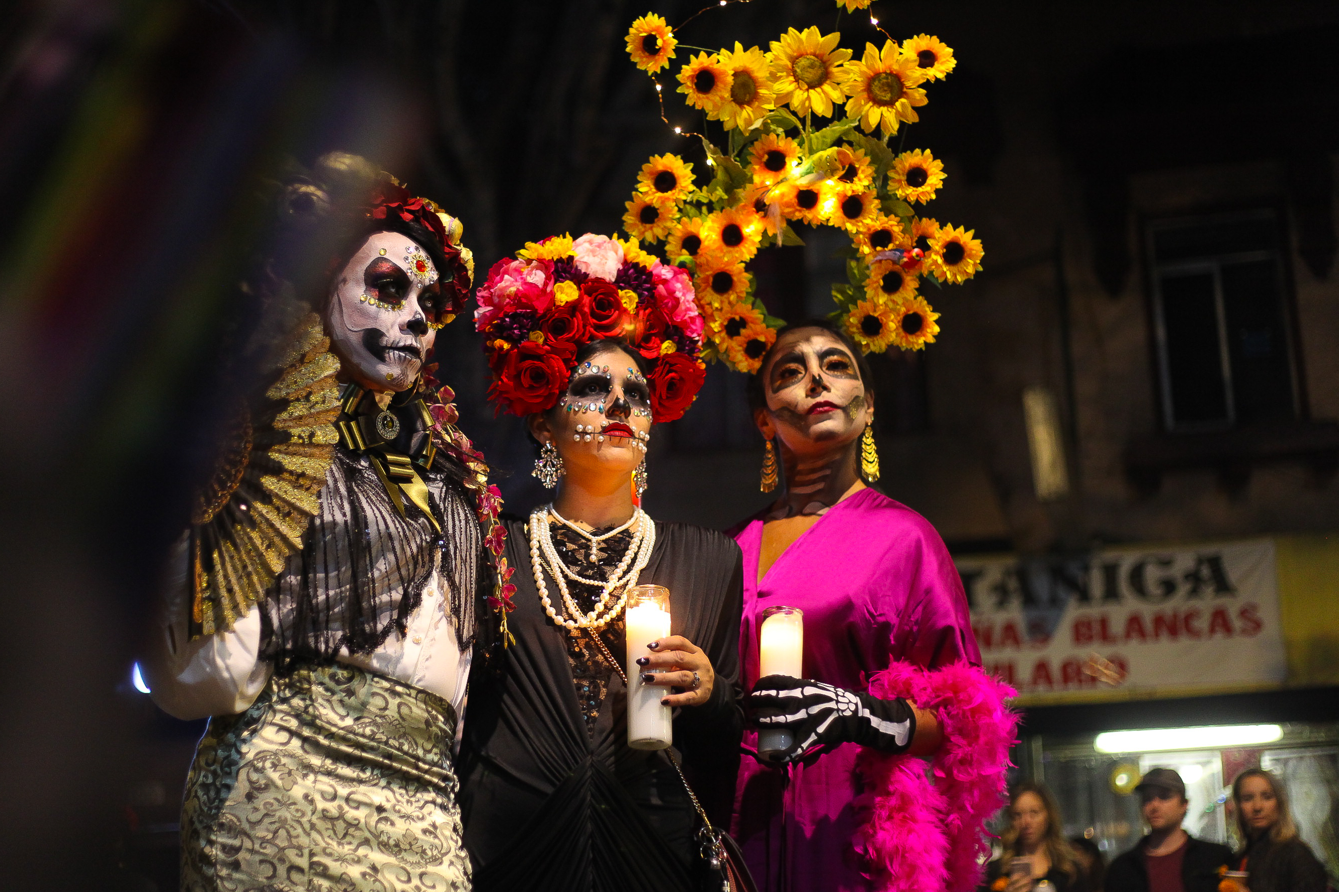 Three women dressed as Catrinas parade in the Mission District