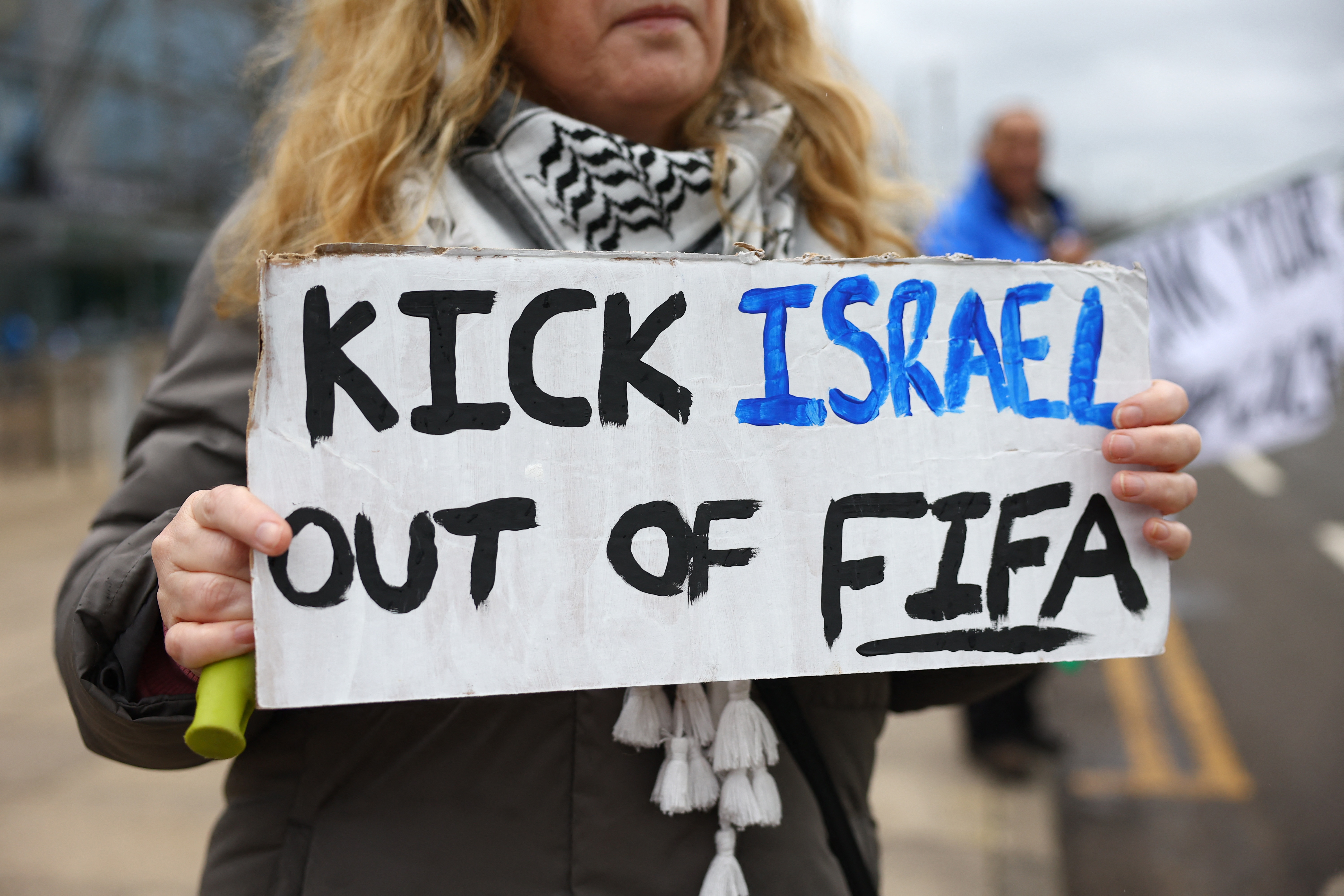 A fan displays a "kick Israel out of FIFA" banner .