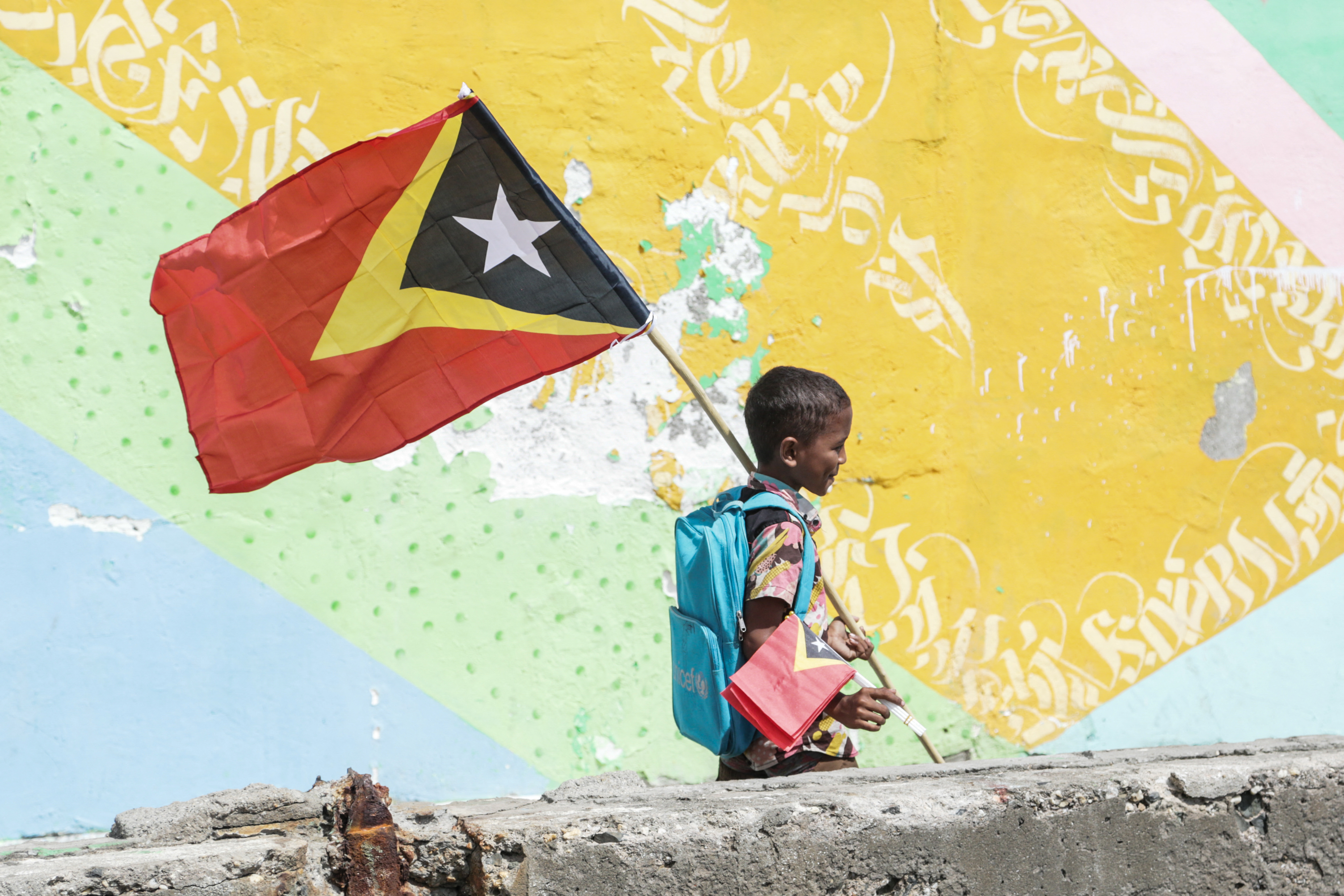A boy holds East Timors national flag as the country celebrates the 23rd anniversary of Independence Day in Dili on May 20, 2025. (Photo by Valentino Dariell DE SOUSA / AFP)