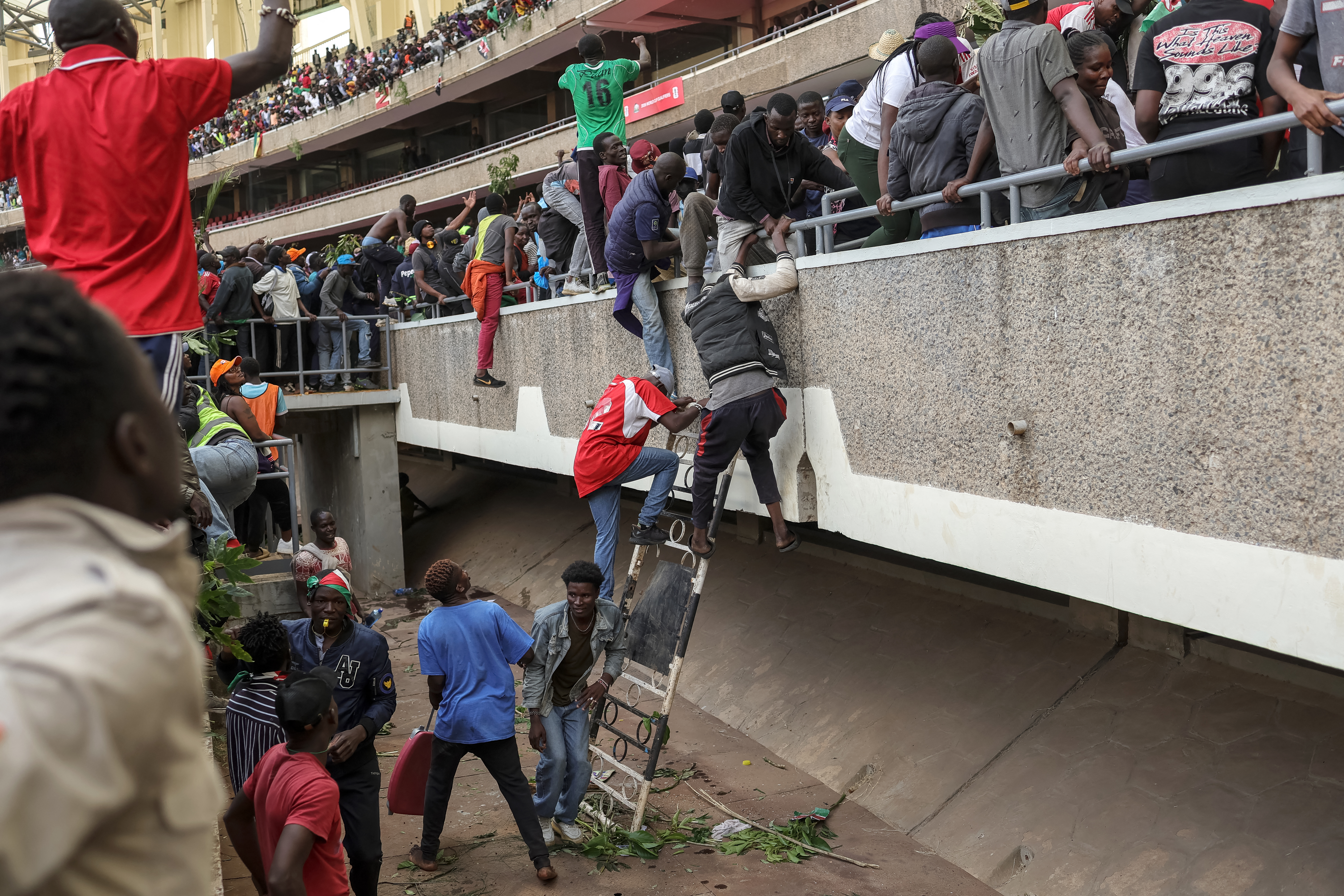 Supporters and mourners of Kenyan opposition leader Raila Odinga run for cover after gunshots were fired during a gathering for the public viewing of his coffin [Tony Karumna/AFP]