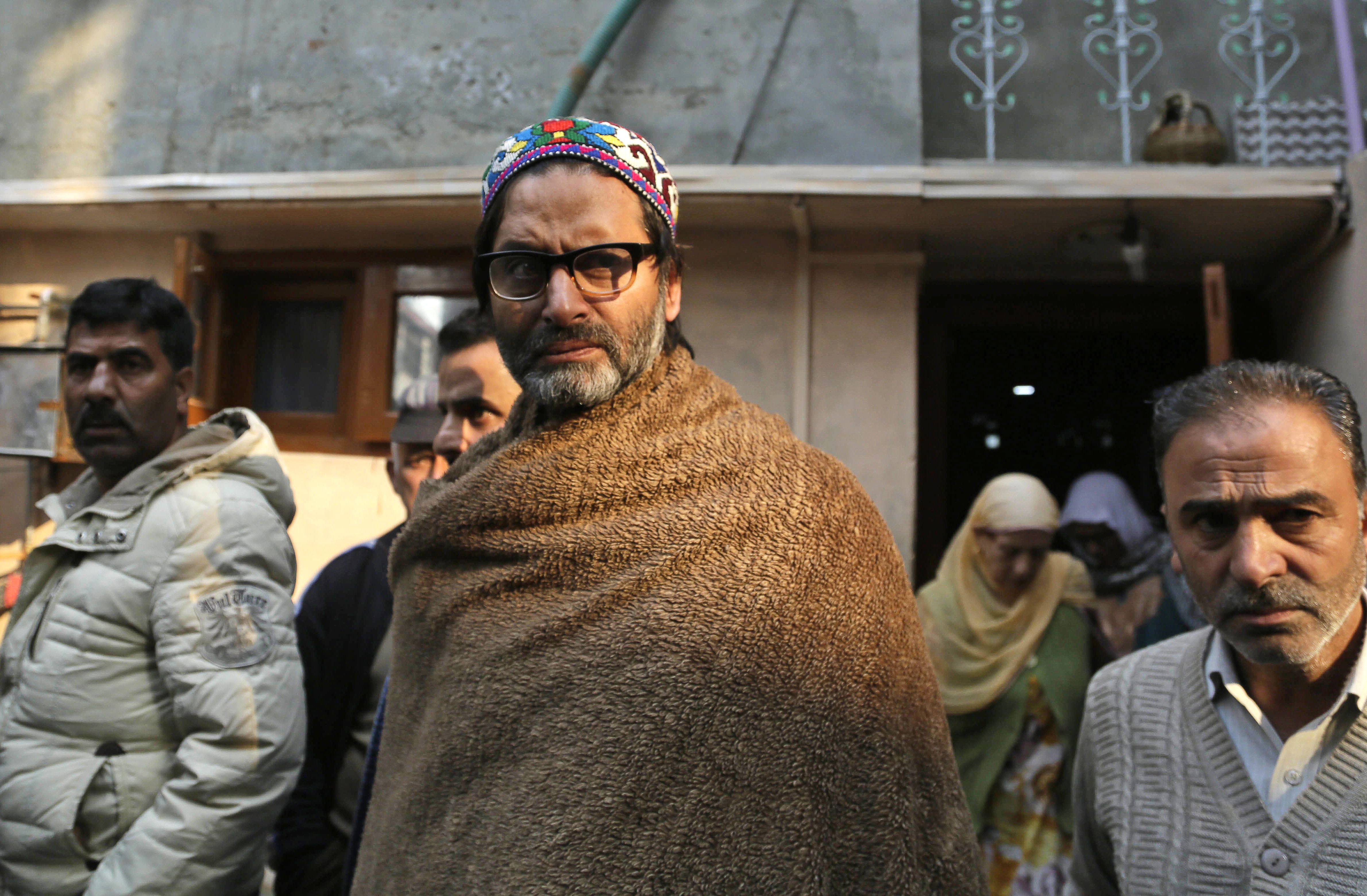 FILE- In this Thursday, Nov. 10, 2016, file photo, Jammu Kashmir Liberation Front (JKLF) Chairman Yasin Malik, center, walks outside his home after he was detained by Indian police in Srinagar, Indian controlled Kashmir. India has banned a pro-independence group in its portion of Kashmir as part of a crackdown on separatist oganizations. A government statement Friday, March 22, 2019 says the Jammu Kashmir Liberation Front, led by Yasin Malik, has been declared as an "unlawful association'' to curb the activities of secessionist organizations posing a threat to the country's unity and integrity. (AP Photo/Mukhtar Khan, file)