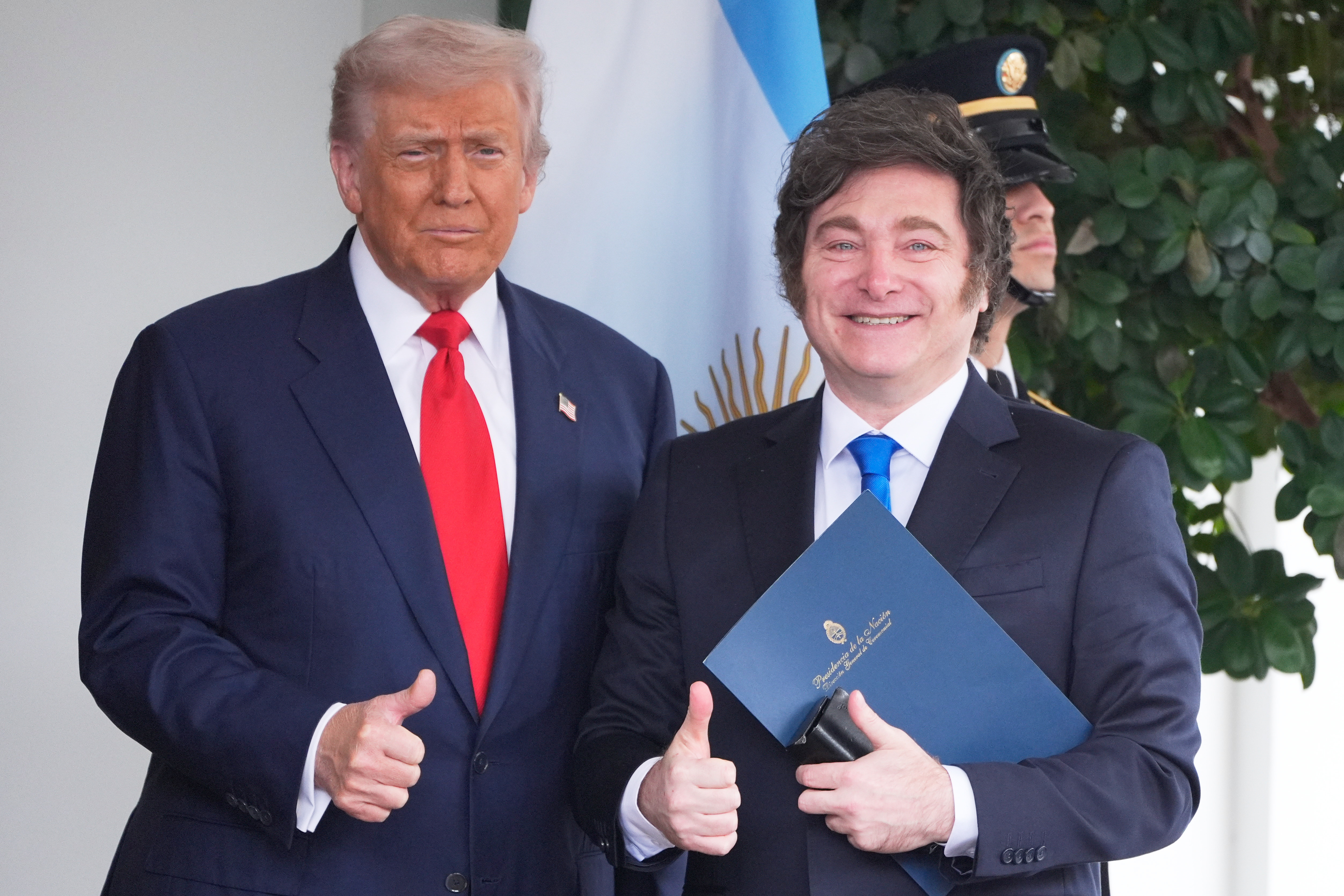 Donald Trump and Javier Milei flash a thumbs-up together outside the White House.