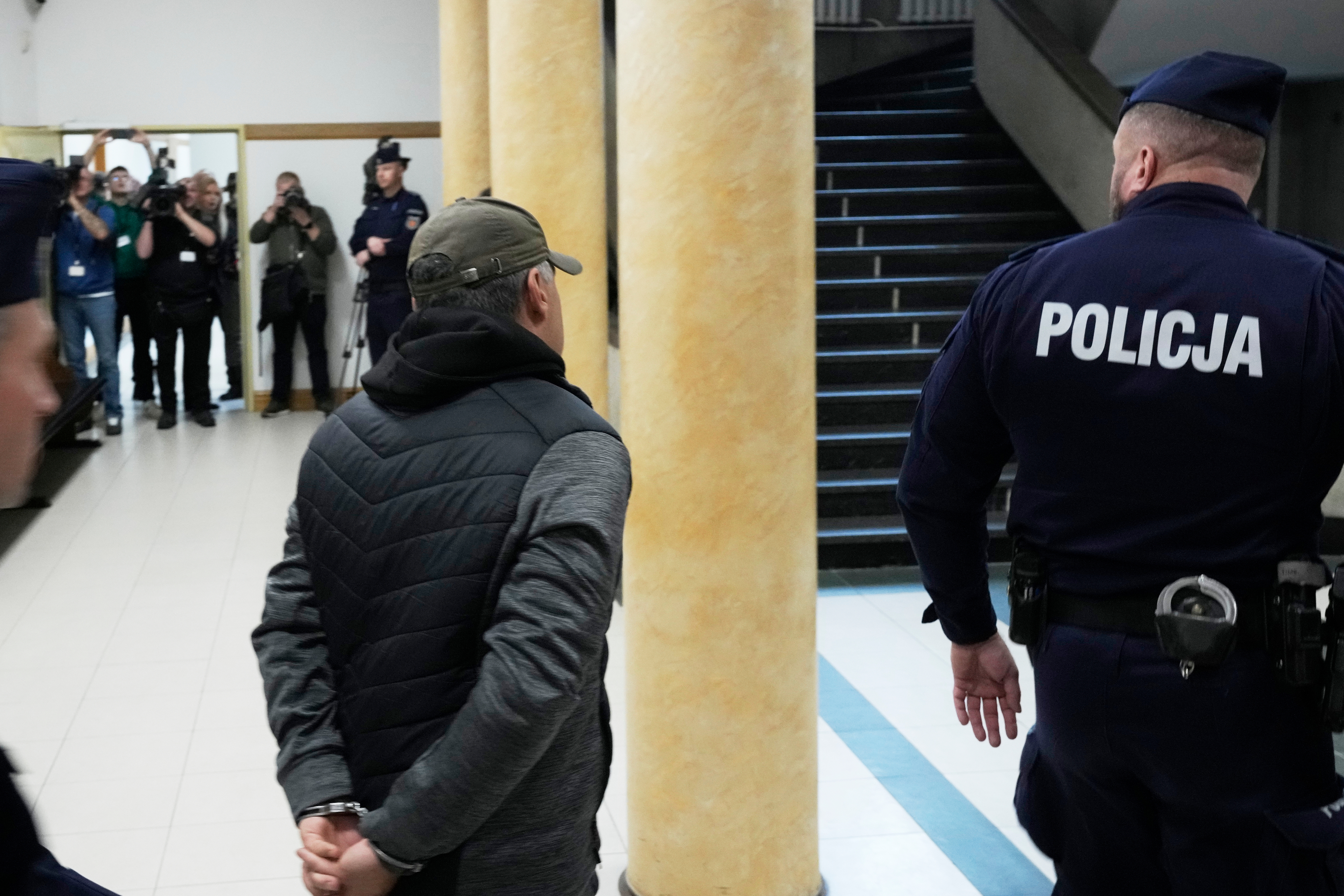 A Ukrainian man who has been identified only as Volodymyr Z, centre, leaves the courtroom of a regional court in Warsaw, Poland on October 17, 2025.