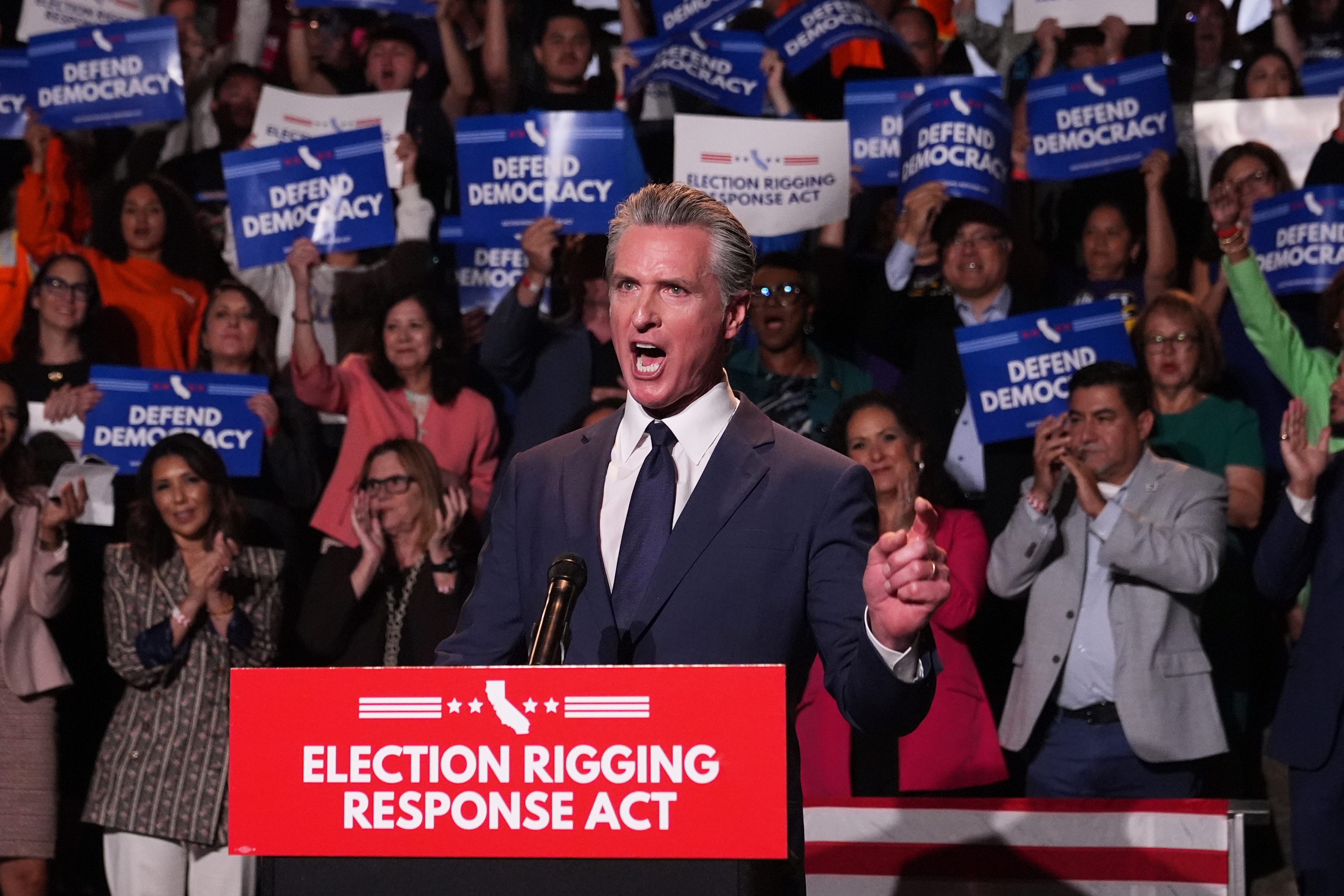 Gavin Newsom speaks at a podium labelled "Election Rigging Response Act"