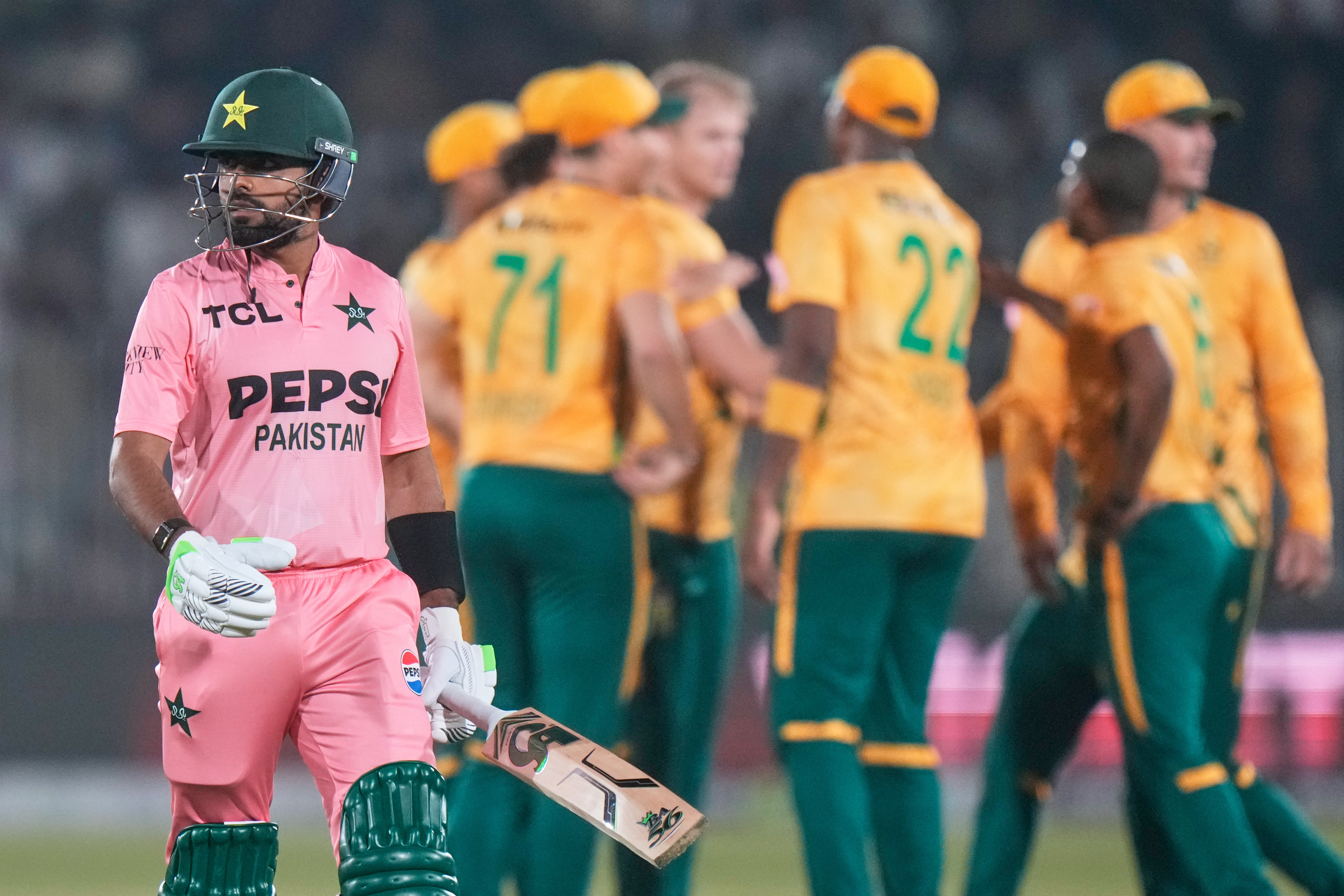 Pakistan's Babar Azam, left, walks off the field as South Africa players celebrates after his dismissal during the first T20 cricket match