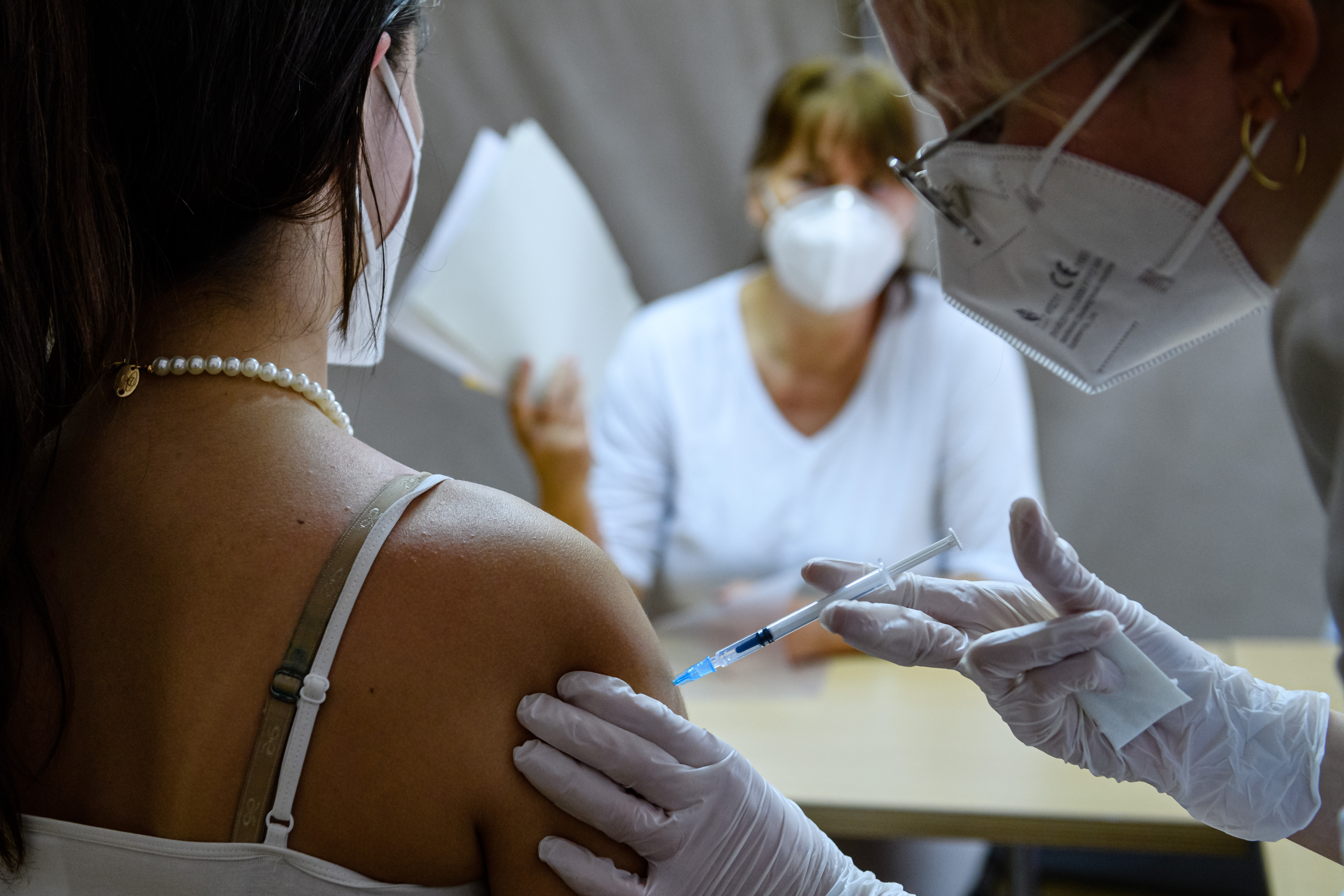A doctor inoculates a patient against COVID-19 with the Pfizer-BioNTech vaccine in Leipzig, Germany, during the global pandemic in 2021 [Jens Schlueter/Getty Images]