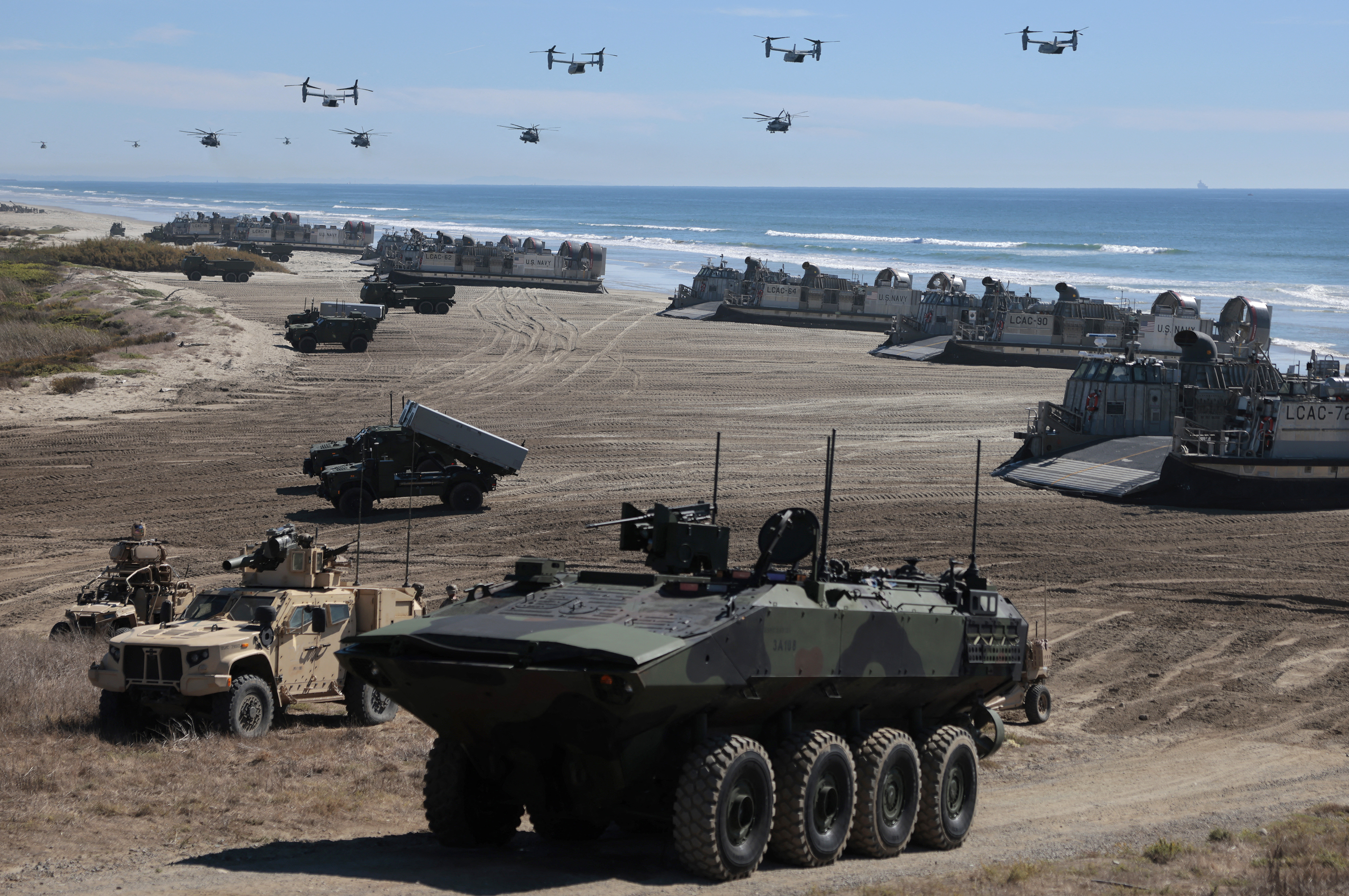 OCEANSIDE, CALIFORNIA - OCTOBER 18: Navy Landing Craft Air Cushion's (LCAC) unload equipment onto the beach as U.S. Marine Corps V-22 Ospreys and CH-53 Super Stallions fly overhead during the America's Marines 250 event at Camp Pendleton's Red Beach on October 18, 2025 in Oceanside, California. The U.S. Marines are marking their 250th anniversary with a live amphibious assault demonstration entitled "Sea To Shore--A Review of Amphibious Strength" and visits from Vice President JD Vance and War Secretary Pete Hegseth. Mario Tama/Getty Images/AFP (Photo by MARIO TAMA / GETTY IMAGES NORTH AMERICA / Getty Images via AFP)