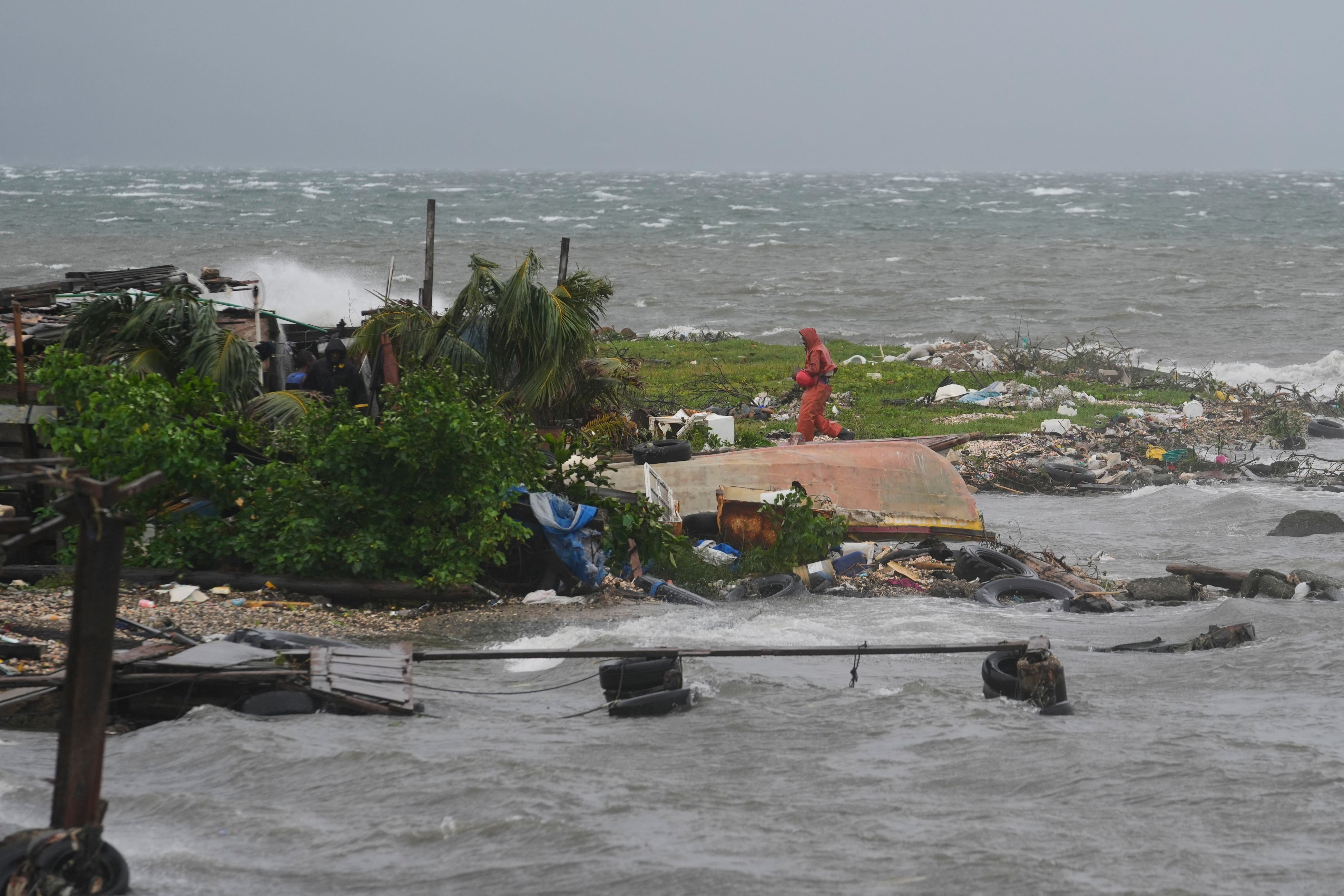A man walks along the coastline in Kingston, Jamaica, as Hurricane Melissa approaches, Tuesday, Oct. 28, 2025. (AP Photo/Matias Delacroix)