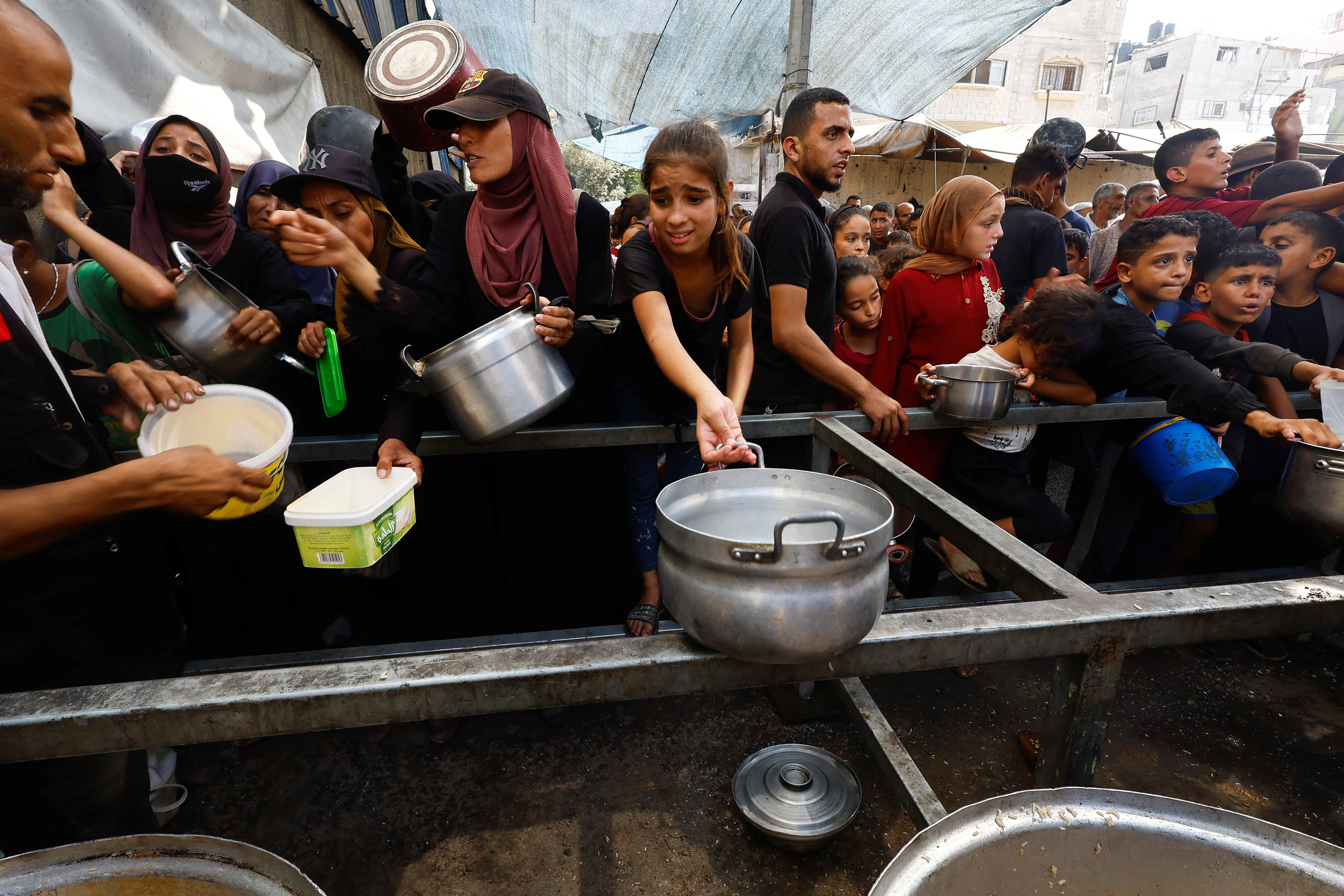 Palestinians gather to receive food from a charity kitchen, in Nuseirat, central Gaza Strip, September 28, 2025. REUTERS/Mahmoud Issa