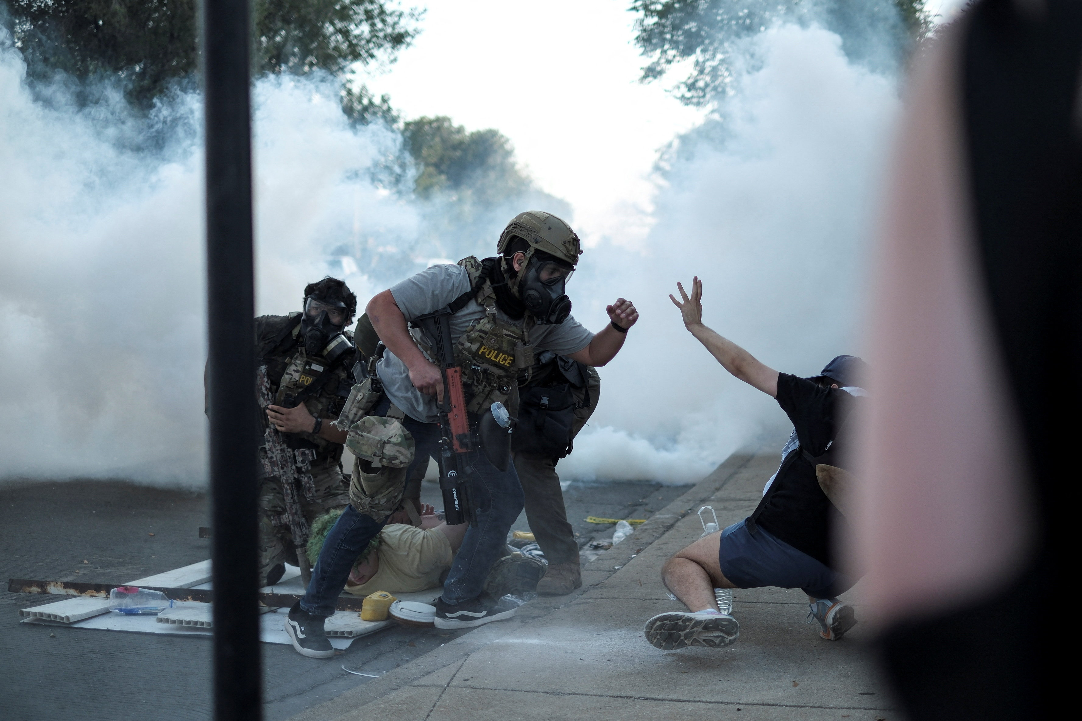 A law enforcement officer confronts a demonstrator, as another one is detained, during a standoff with U.S. Immigration and Customs Enforcement (ICE) and federal officers in the Little Village neighborhood of Chicago, Illinois, U.S., October 4, 2025. REUTERS/Jim Vondruska