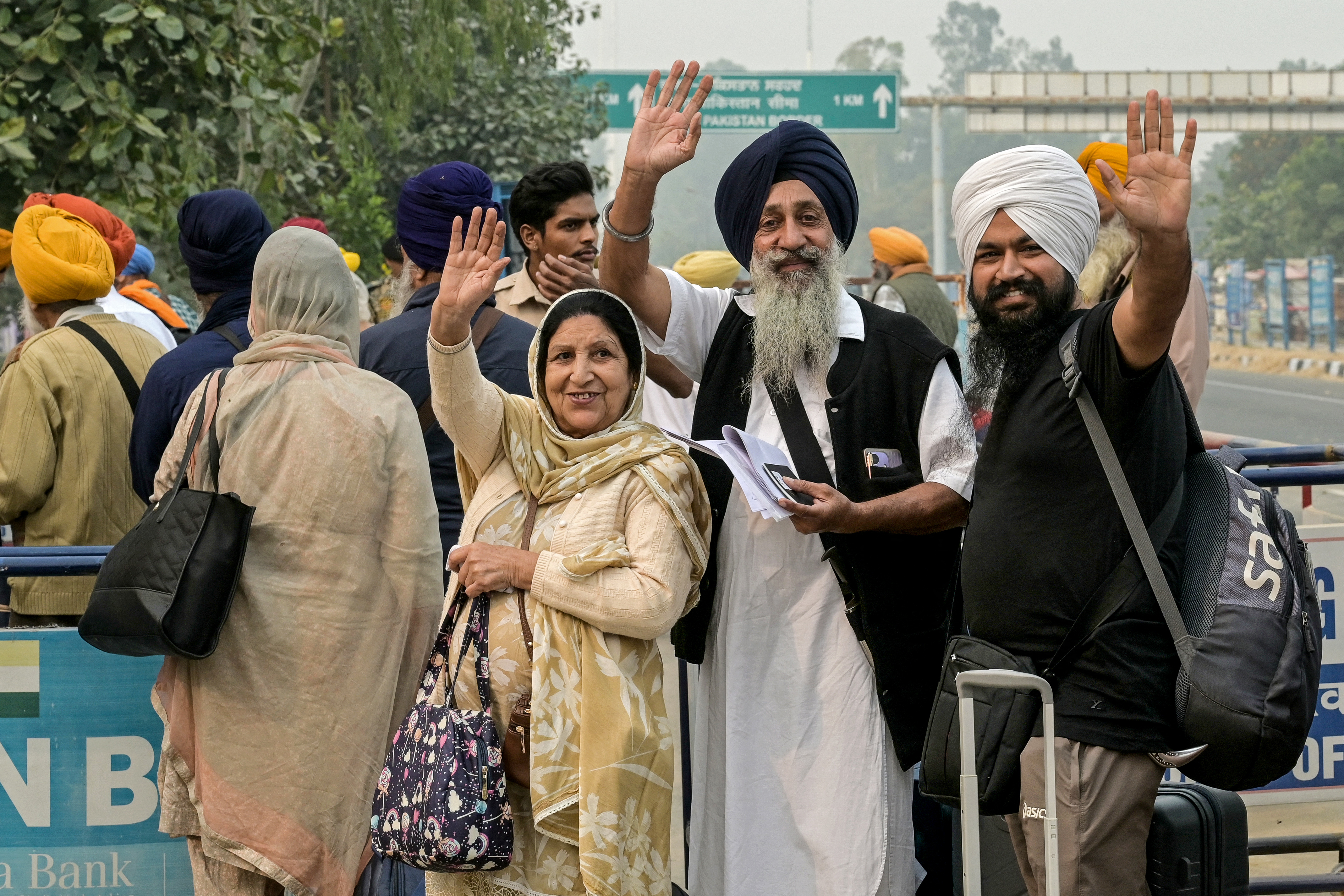 Indian Sikh pilgrims wave as they head to Pakistan through the India-Pakistan Wagah border