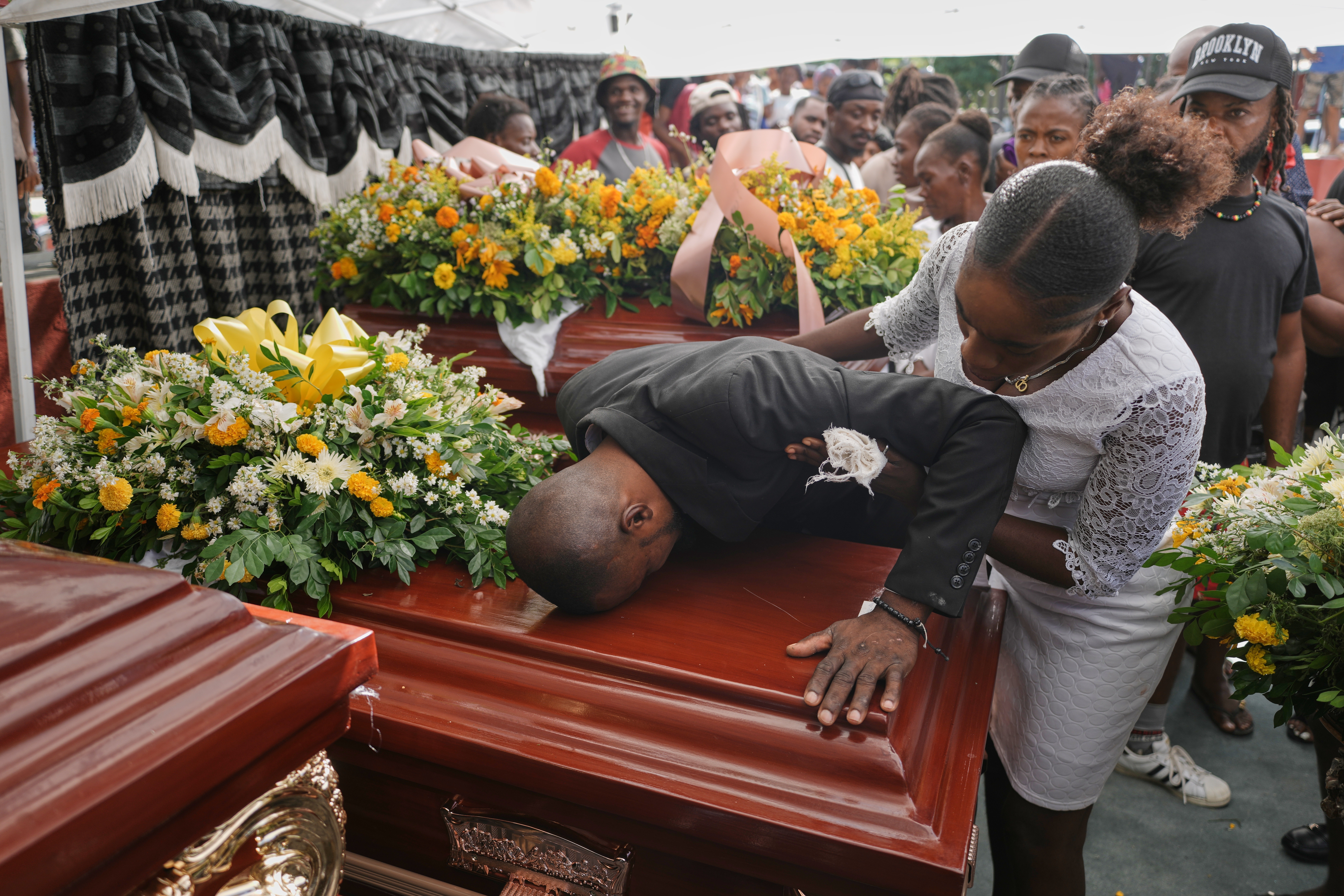 Relatives of Rosiclaire Lenchise mourn during the funeral of victims killed by a landslide triggered by Hurricane Melissa in Petit Goave, Haiti
