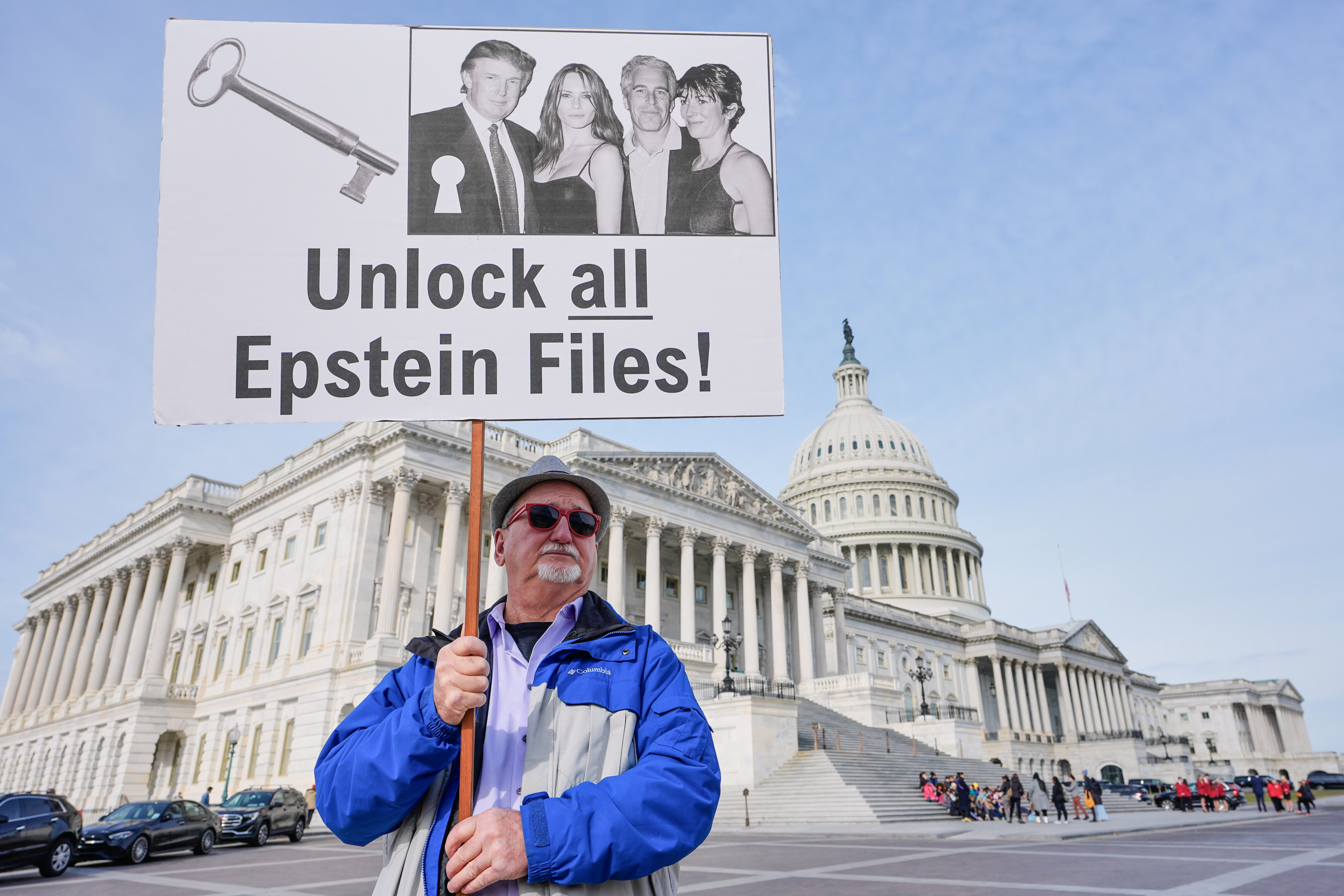 A man holds a sign demanding release of the Epstein files