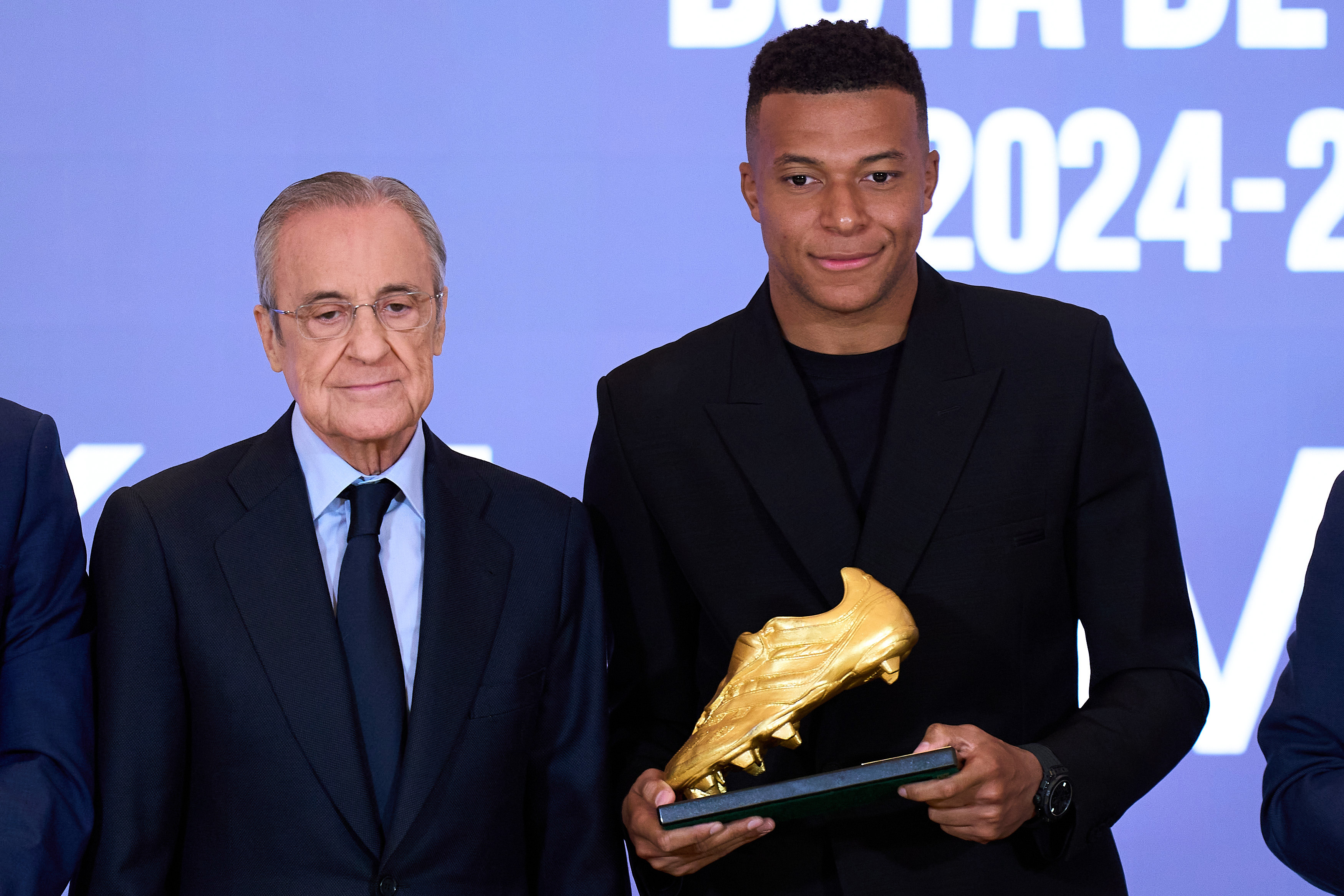 Kylian Mbappe (R) of Real Madrid poses with Florentino Perez, president of the club, after receiving a trophy.
