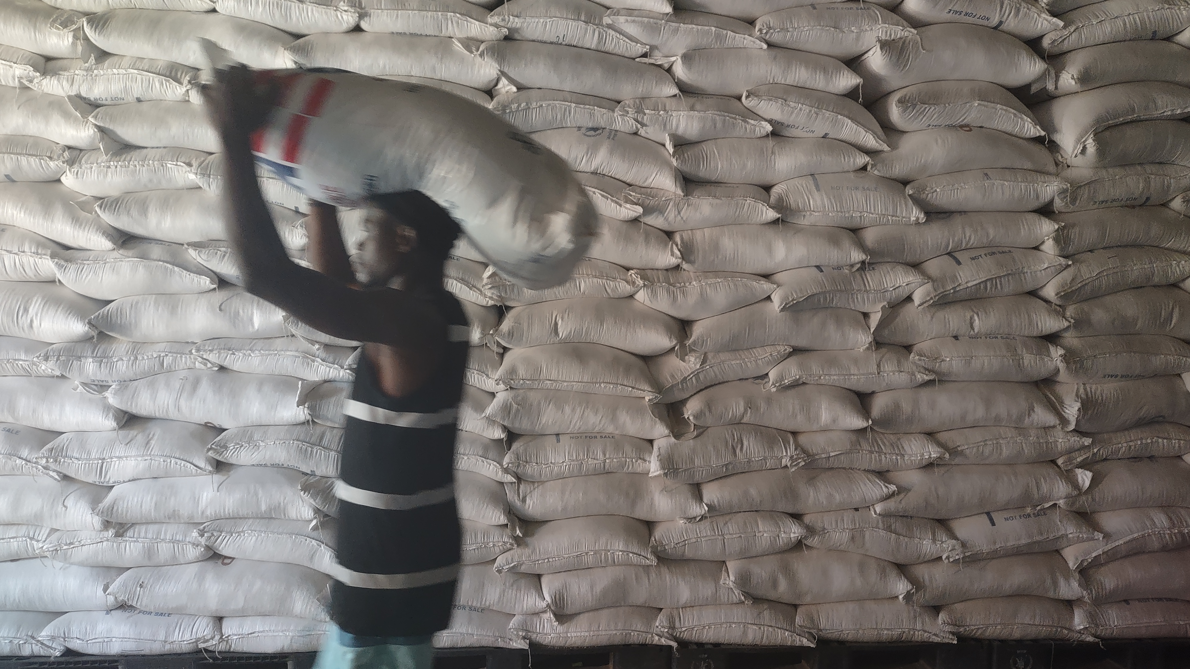 A man carries a bag of rice over his head