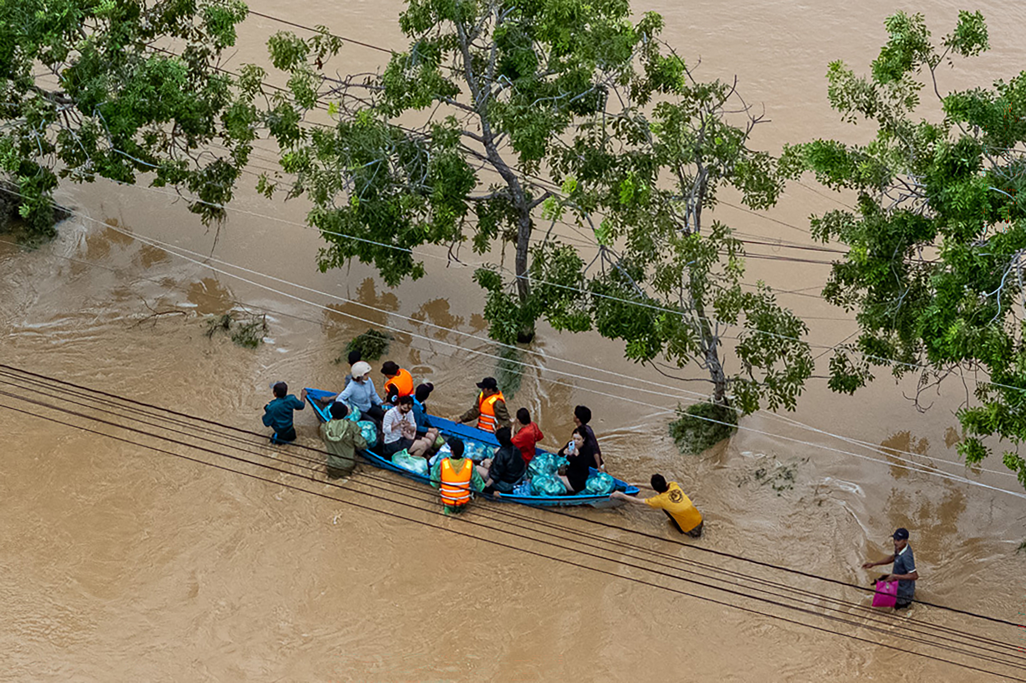This aerial photo shows people wading through floodwaters in Phan Rang in southern Vietnam's Khanh Hoa province on November 21, 2025.