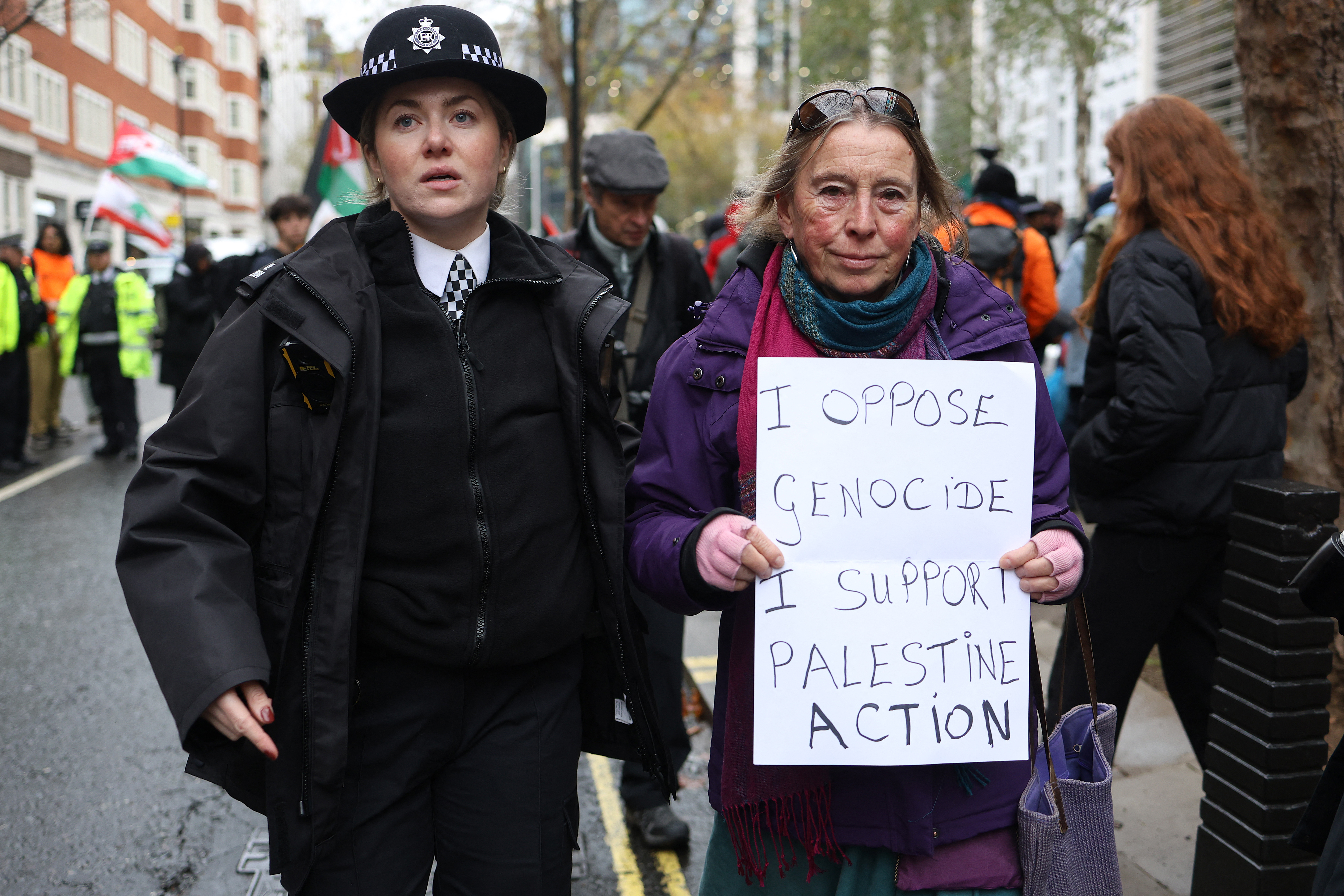 Police remove a protester for taking part in a demonstration in support Palestine Acton" during a demonstration in support of "Defend Our Juries" and their campaign against the ban on Palestine Action, outside Britain's Home Office in London on November 24, 2025.